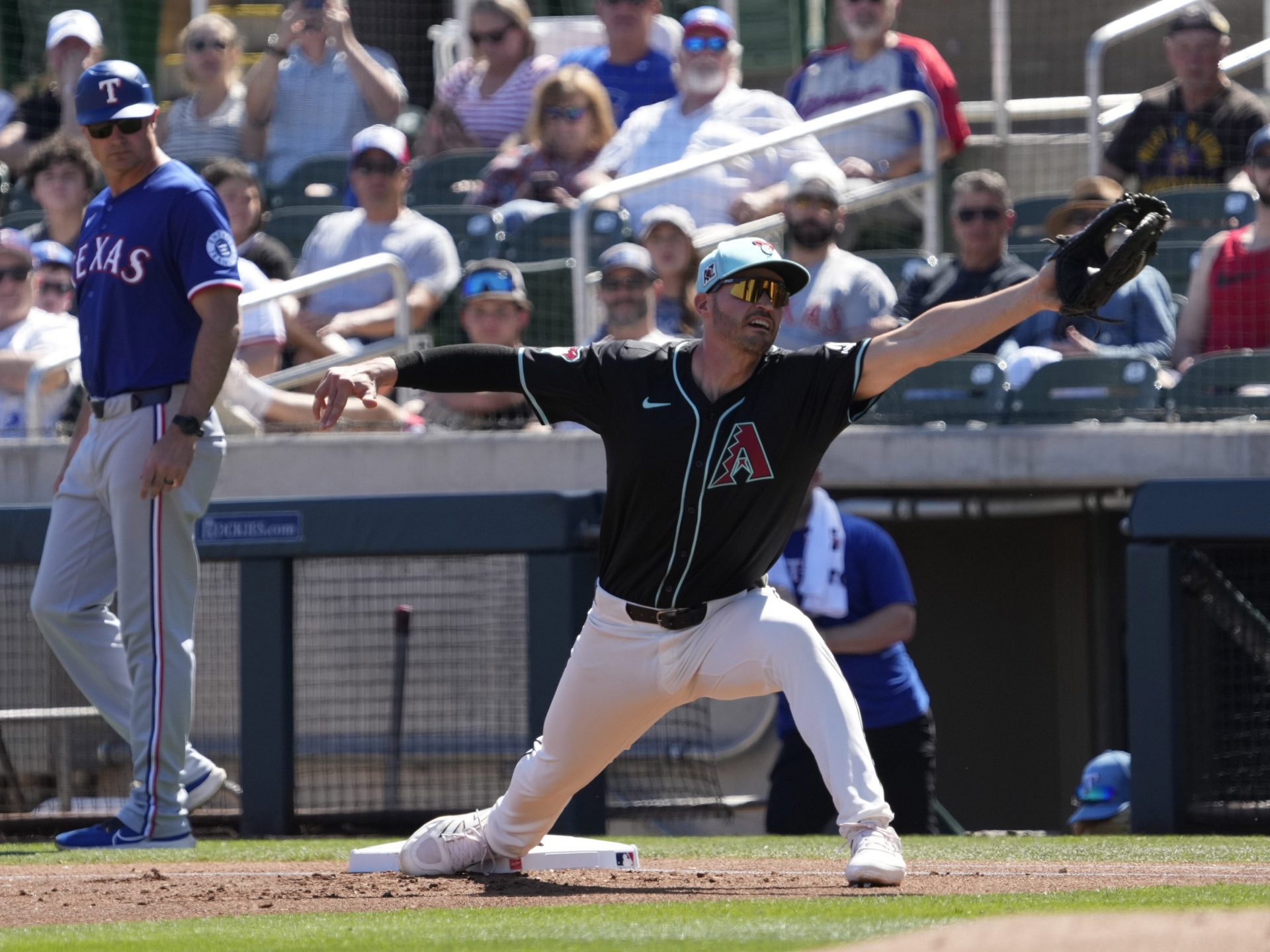 Arizona Diamondbacks first baseman Trey Mancini stretches for a throw against the Texas Rangers during Cactus League play at Salt River Fields on March 9, 2025. Credit: IMAGN