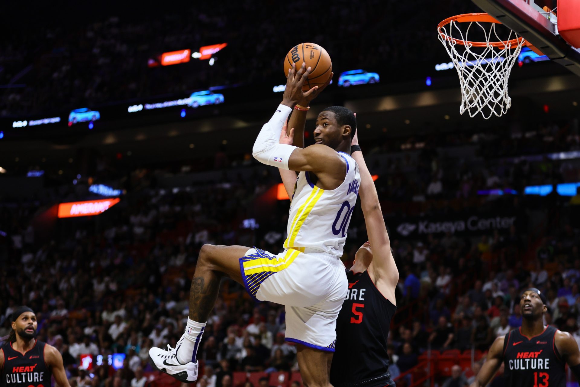 Golden State Warriors forward Jonathan Kuminga (00) passes the ball as Miami Heat forward Nikola Jovic (5) defends during the first quarter at Kaseya Center.