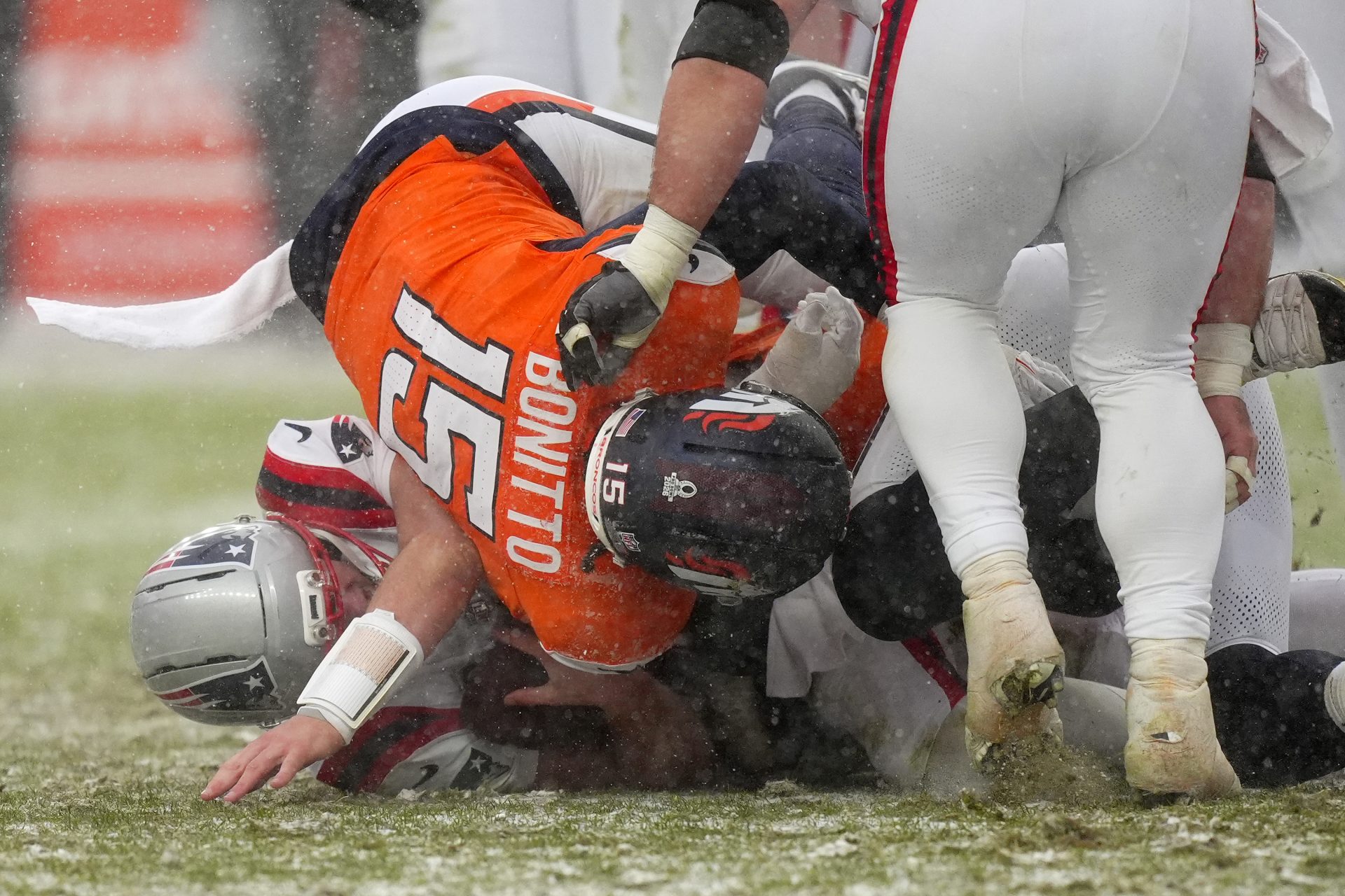 Denver Broncos linebacker Nik Bonitto (15) tackles New England Patriots quarterback Drake Maye (10) during the second half in the 2026 AFC Championship Game at Empower Field at Mile High.