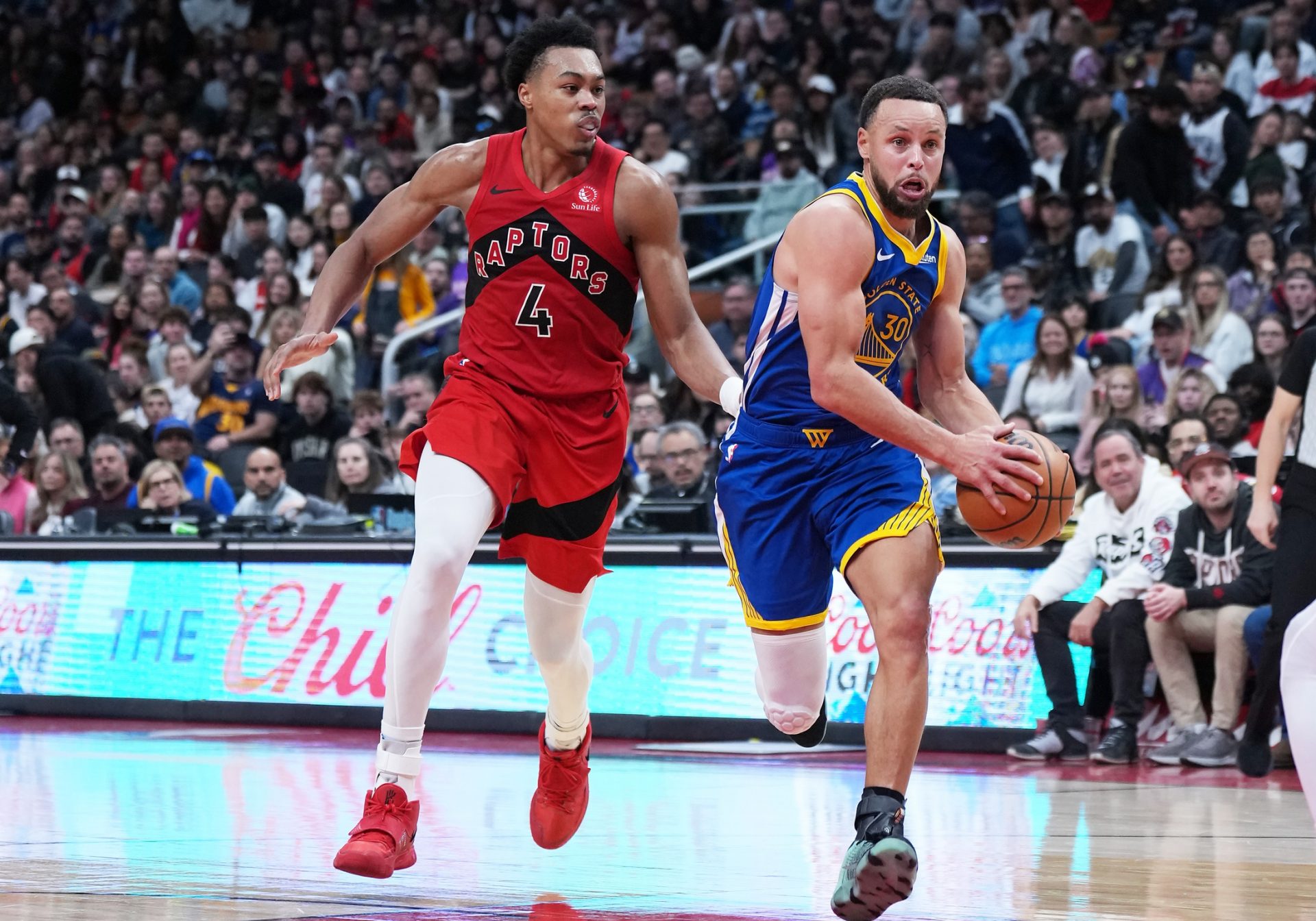 Golden State Warriors guard Stephen Curry (30) controls the ball as Toronto Raptors forward Scottie Barnes (4) tries to defend during the overtime at Scotiabank Arena.
