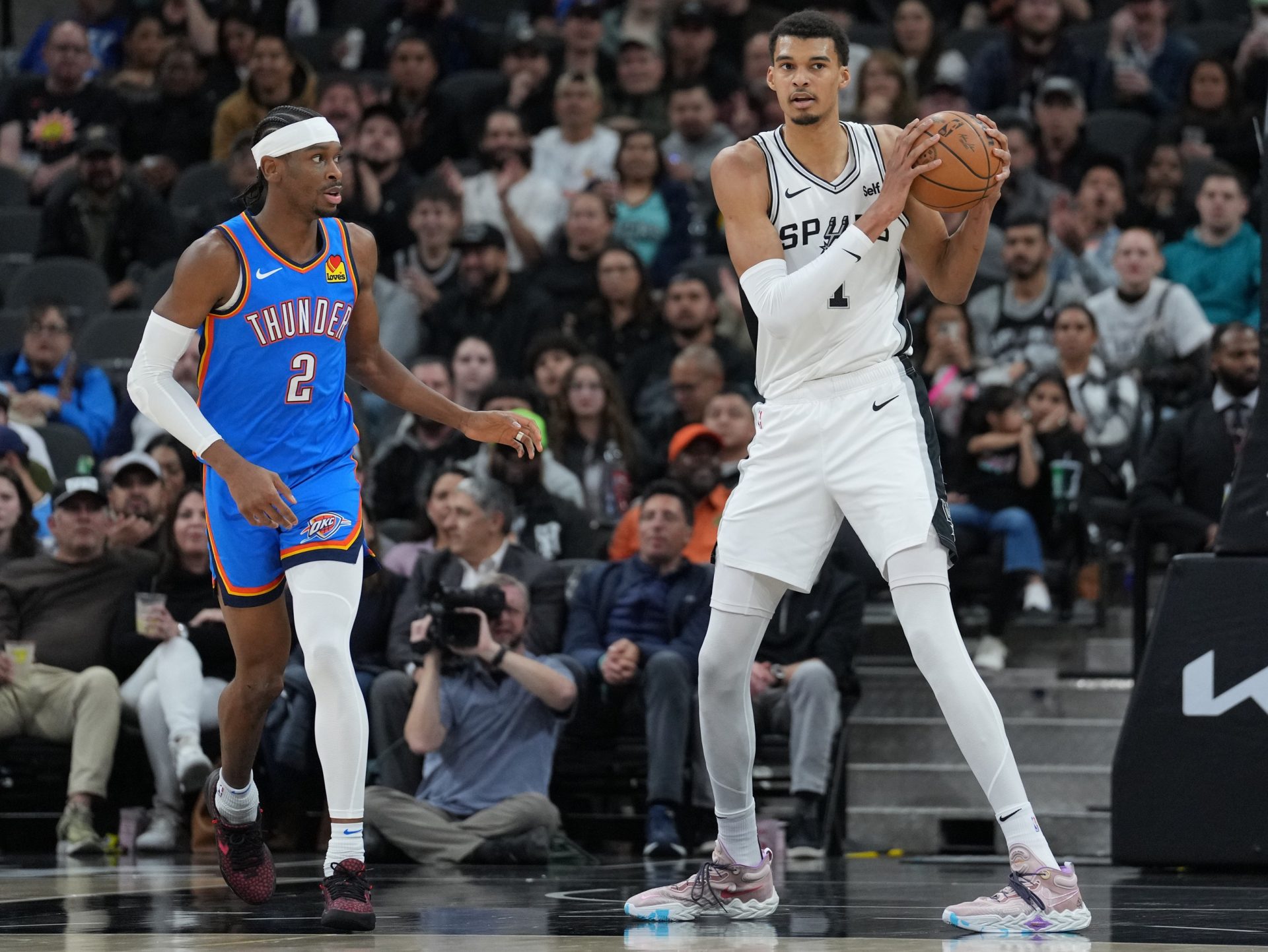 San Antonio Spurs center Victor Wembanyama (1) looks down the court beside Oklahoma City Thunder guard Shai Gilgeous-Alexander (2) in the first half at Frost Bank Center.