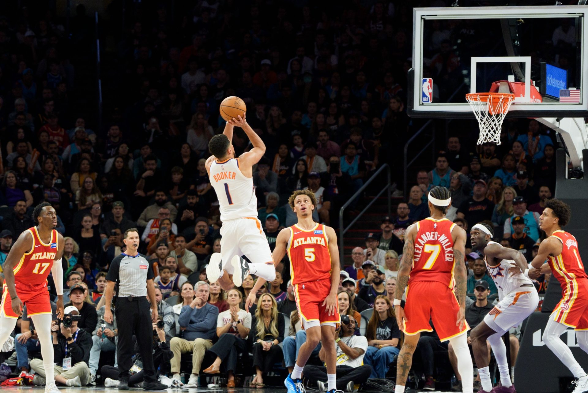 Phoenix Suns guard Devin Booker (1) leaps and shoots the ball as Atlanta Hawks guard Dyson Daniels (5) watches on during the second half of a game at Mortgage Matchup Center.