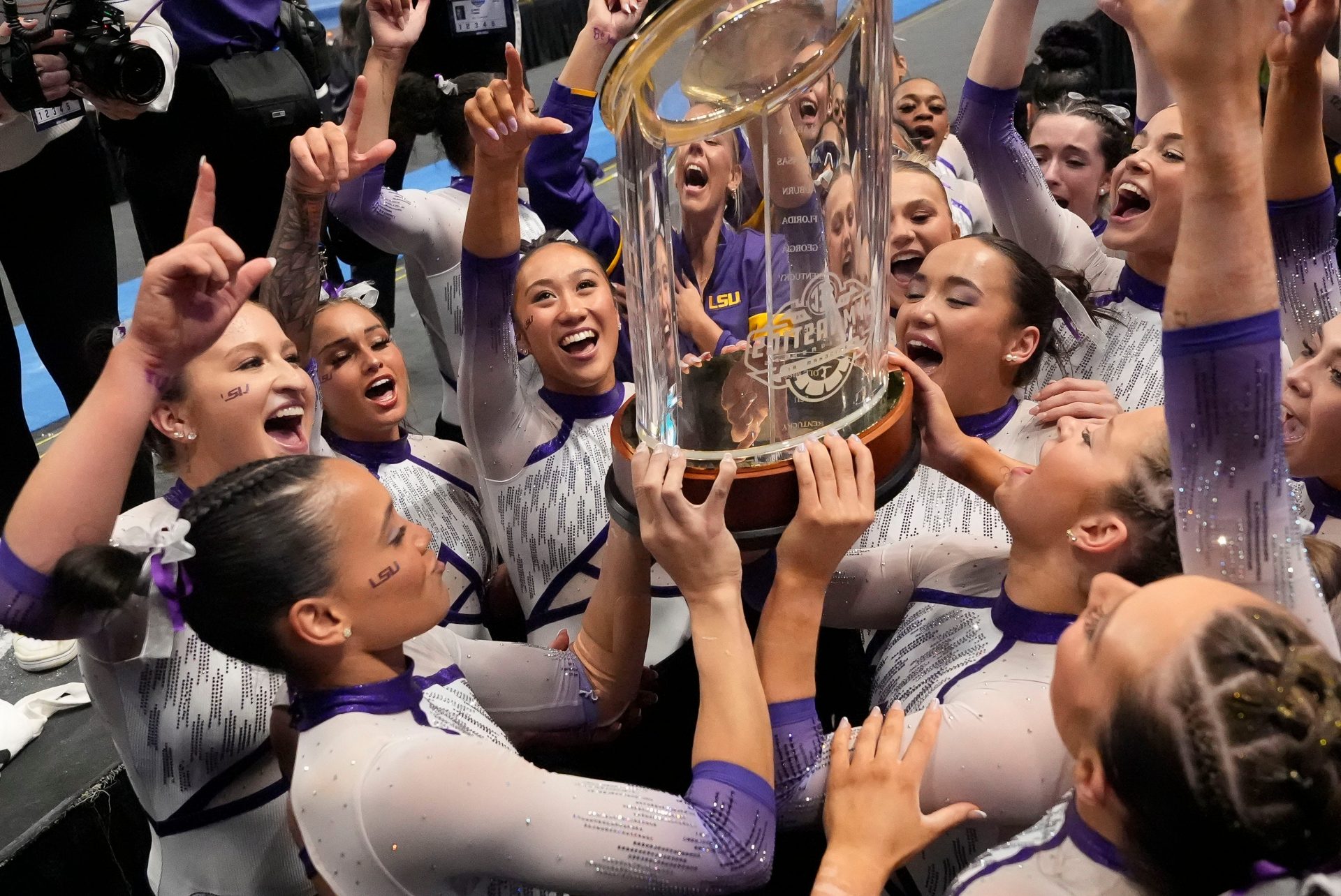 LSU gymnasts celebrate with the championship trophy after Session 2 competition at the SEC Gymnastics Championship at Legacy Arena in Birmingham, Alabama. LSU won the event to claim the SEC crown.
