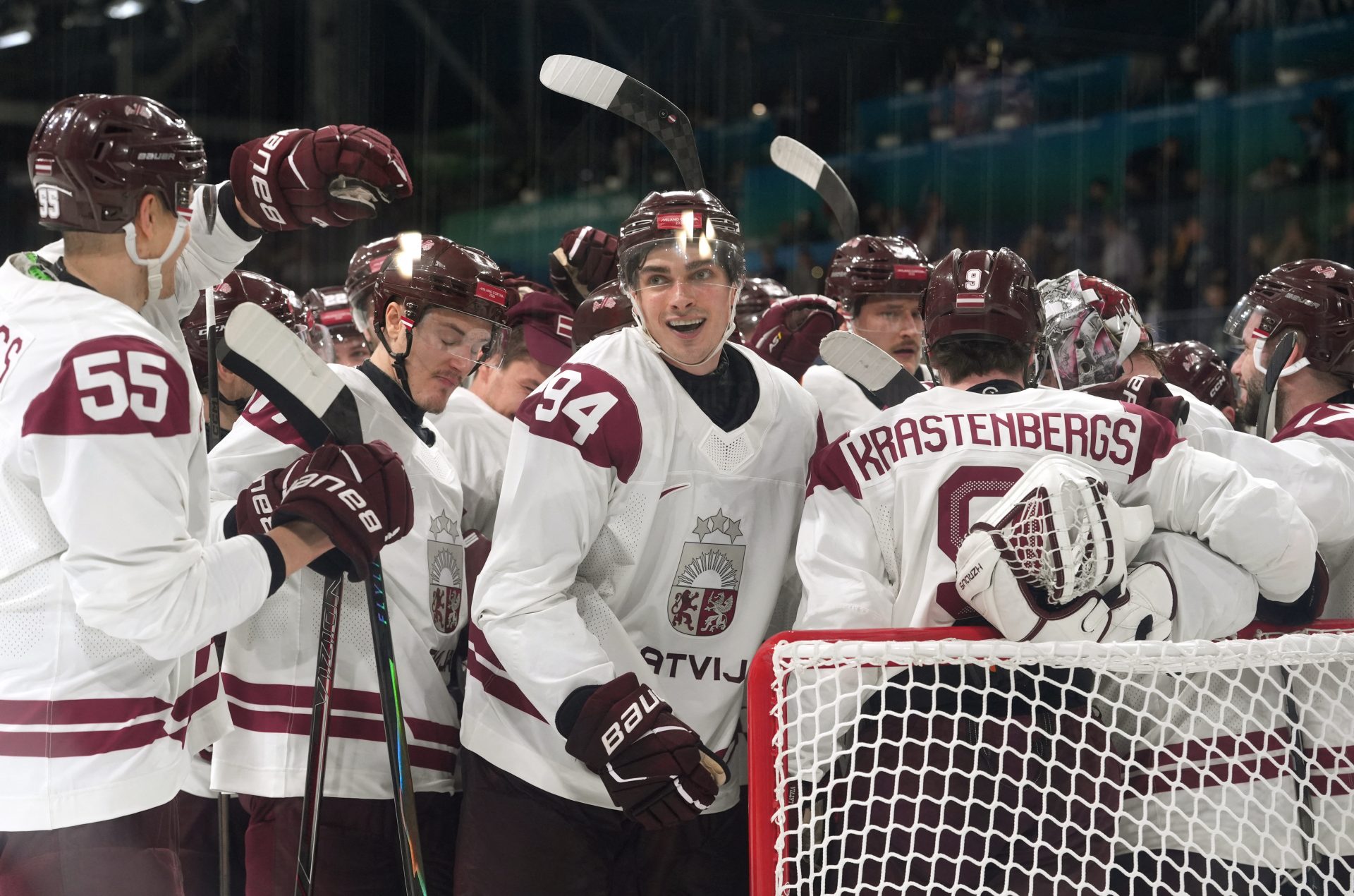 Latvia players celebrate after the match during a Group C men's ice hockey game during the Milano Cortina 2026 Olympic Winter Games at Milano Rho Ice Hockey Arena.