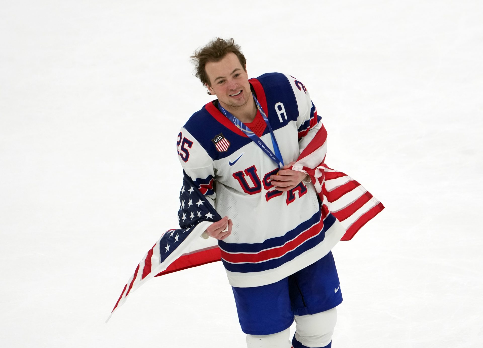 Charlie McAvoy of the United States (center) celebrates after winning the men's ice hockey gold medal game during the Milano Cortina 2026 Olympic Winter Games at Milano Santagiulia Ice Hockey Arena.