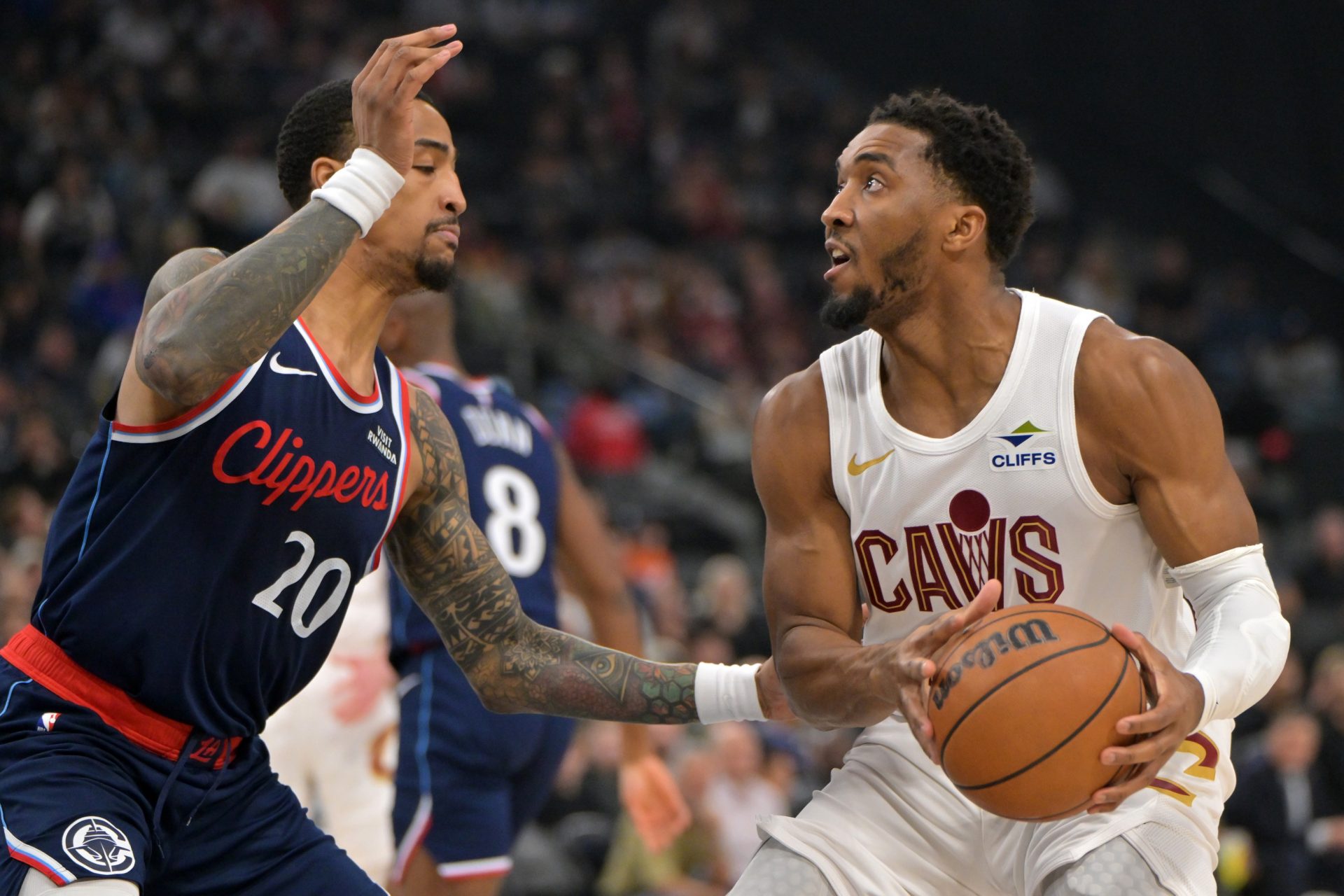 Los Angeles Clippers forward John Collins (20) is charged with a foul on Cleveland Cavaliers guard Donovan Mitchell (45) in the first half at Intuit Dome.