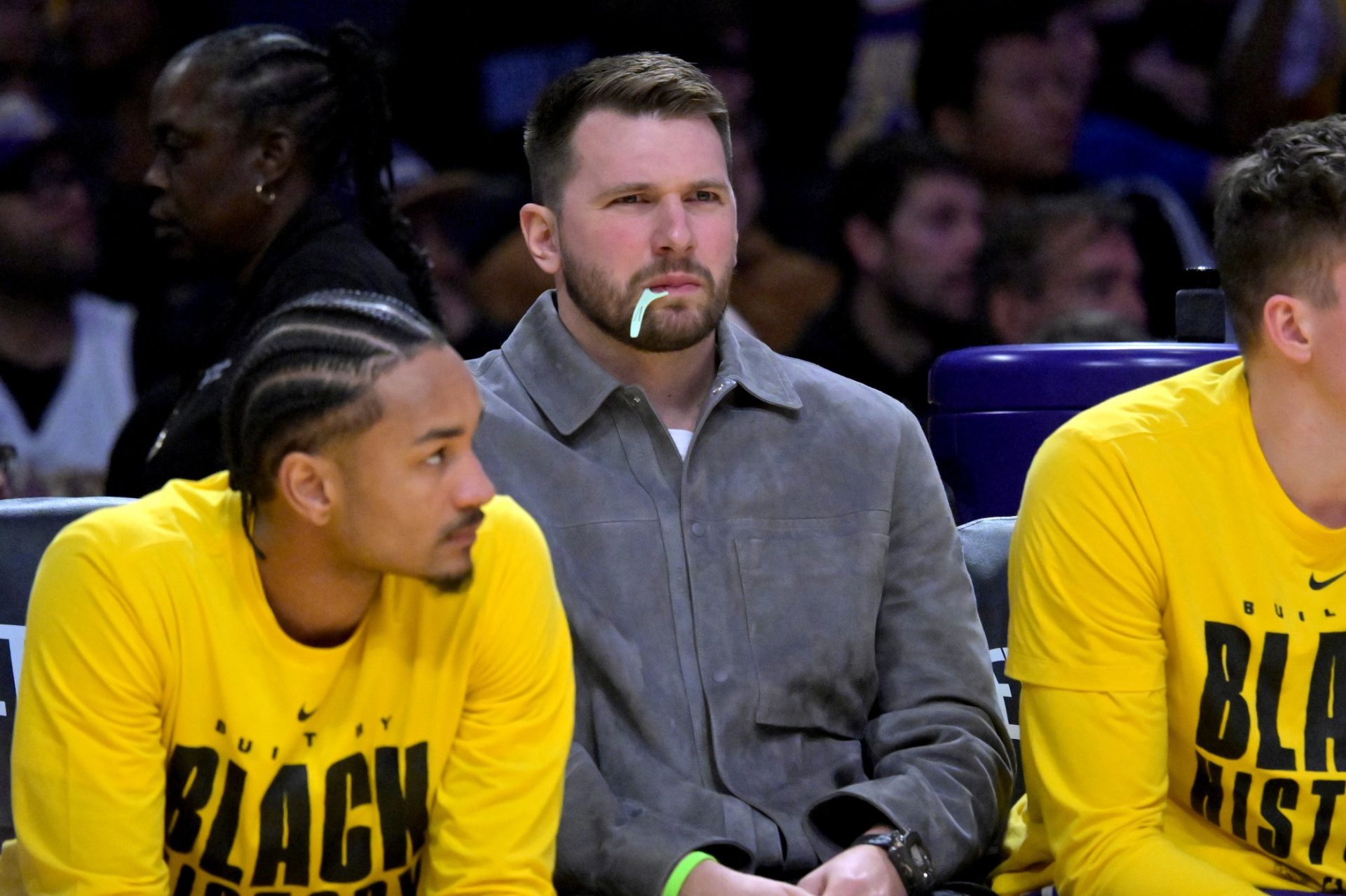 Los Angeles Lakers guard Luka Doncic (77) looks on from the bench as he chews on a dental flosser in the second half against the Dallas Mavericks at Crypto.com Arena.