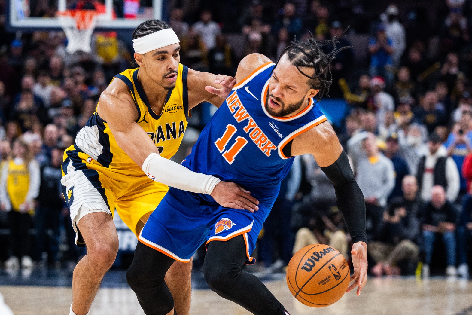 New York Knicks guard Jalen Brunson (11) dribbles the ball while  Indiana Pacers guard/forward Andrew Nembhard (2) defends in the second half at Gainbridge Fieldhouse.