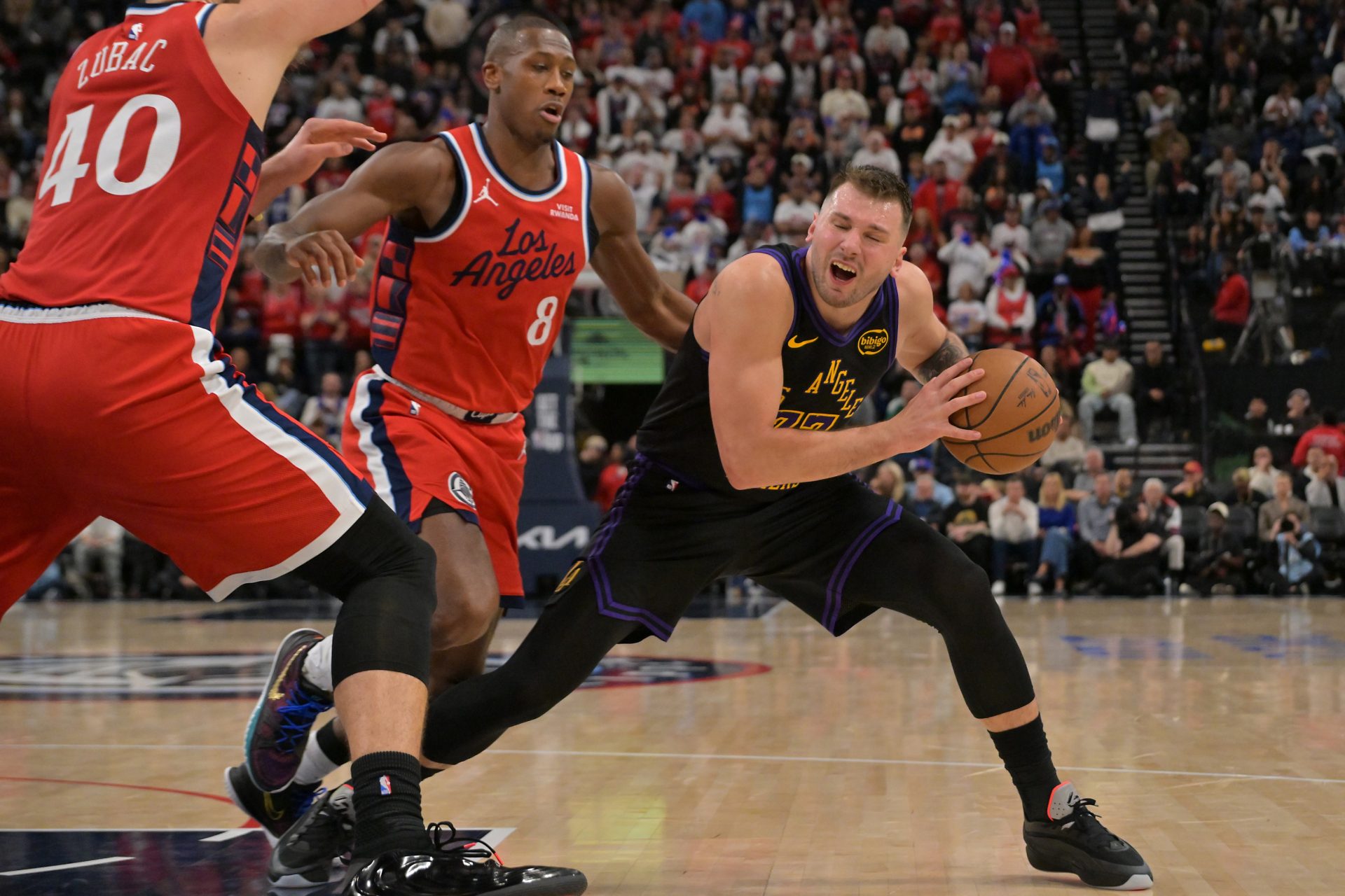 Los Angeles Lakers guard Luka Doncic (77) is defended by Los Angeles Clippers center Ivica Zubac (40) and guard Kris Dunn (8) in the second half at Intuit Dome.