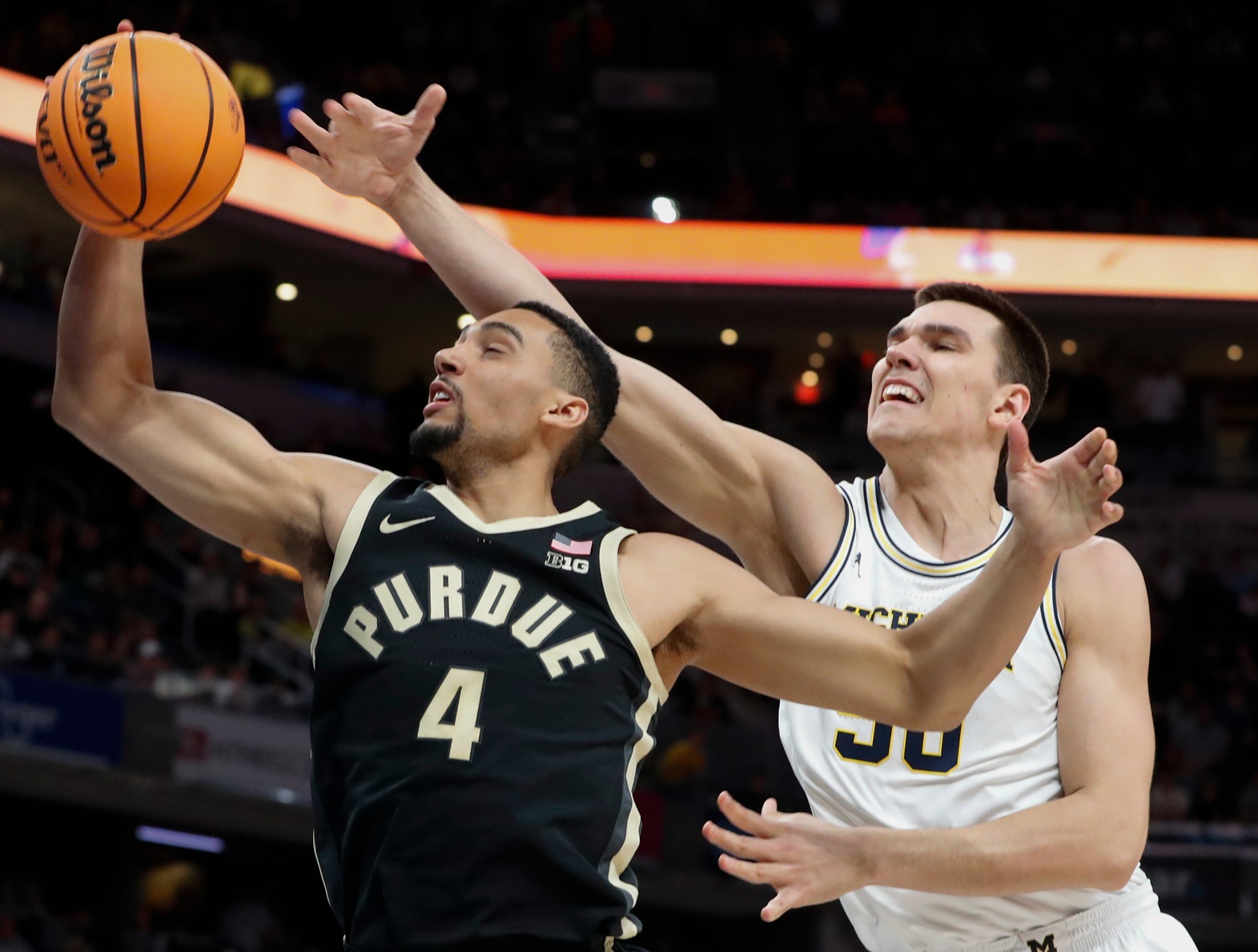 Purdue Boilermakers forward Trey Kaufman-Renn (4) grabs a rebound over Michigan Wolverines center Vladislav Goldin (50) Friday, March 14, 2025, during the Big Ten Menâ€™s Basketball Tournament game at Gainbridge Fieldhouse in Indianapolis.