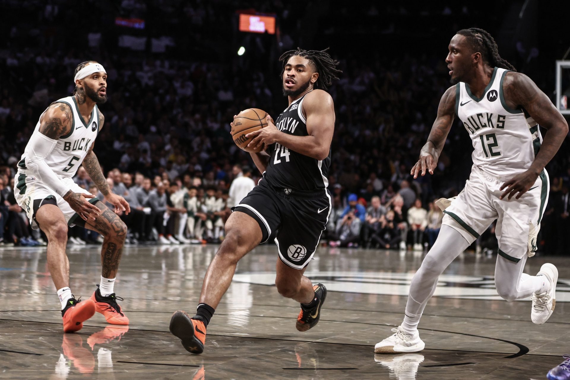 Brooklyn Nets guard Cam Thomas (24) drives past Milwaukee Bucks guard Gary Trent Jr. (5) and forward Taurean Prince (12) in the third quarter against the Milwaukee Bucks at Barclays Center.