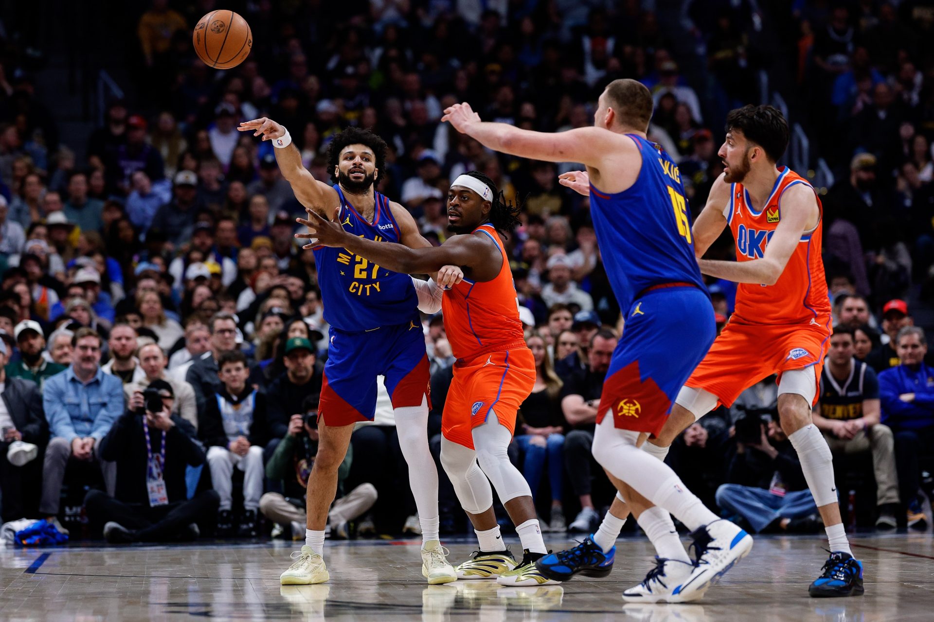 Denver Nuggets guard Jamal Murray (27) passes the ball to center Nikola Jokic (15) under pressure from Oklahoma City Thunder guard Luguentz Dort (5) as center Chet Holmgren (7) defends in the second quarter at Ball Arena - Source: Imagn Images
