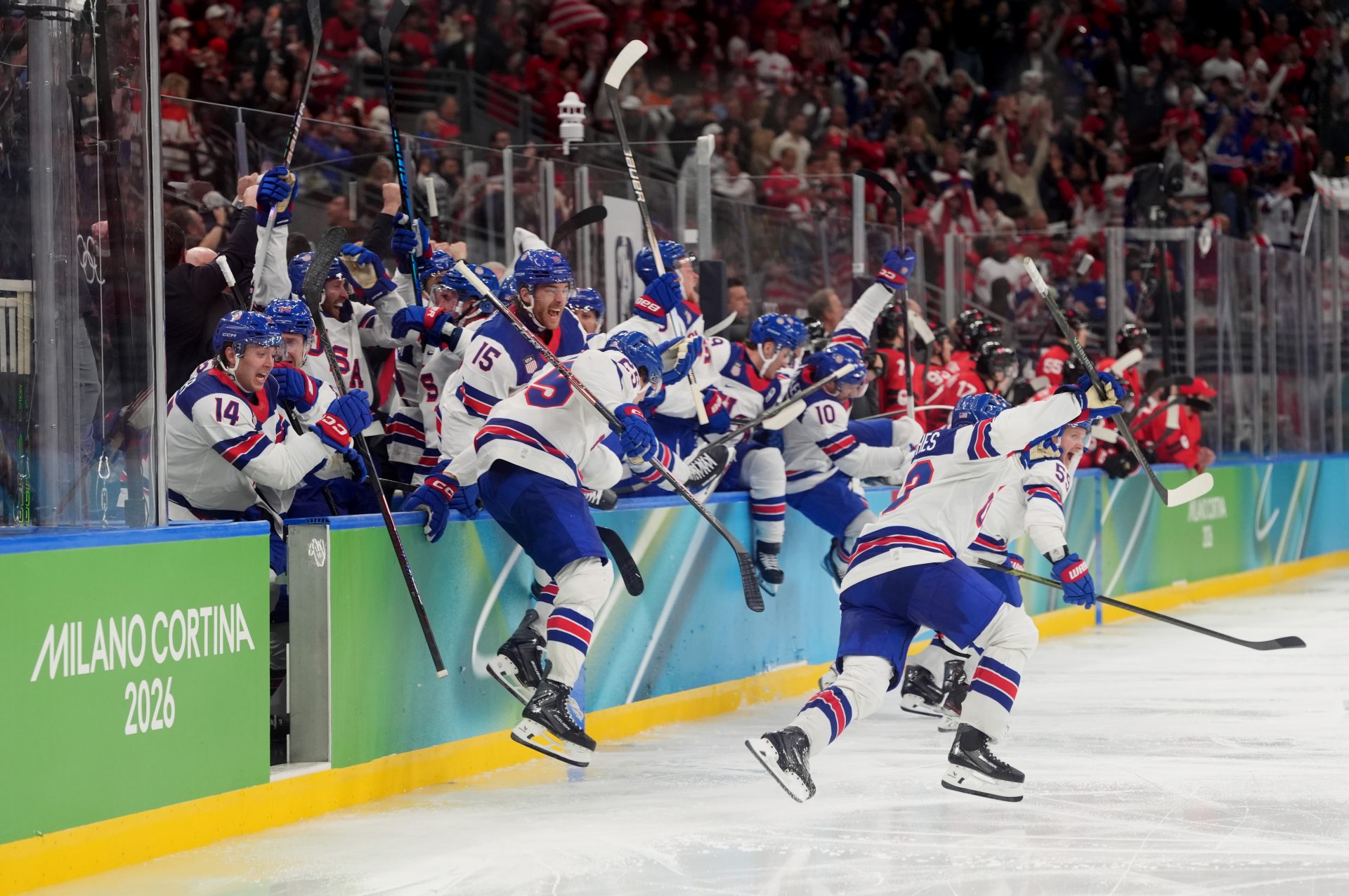 United States bench react after the game-winning goal is scored by Jack Hughes (not pictured) of the United States against Canada in the men's ice hockey gold medal game during the Milano Cortina 2026 Olympic Winter Games at Milano Santagiulia Ice Hockey Arena.