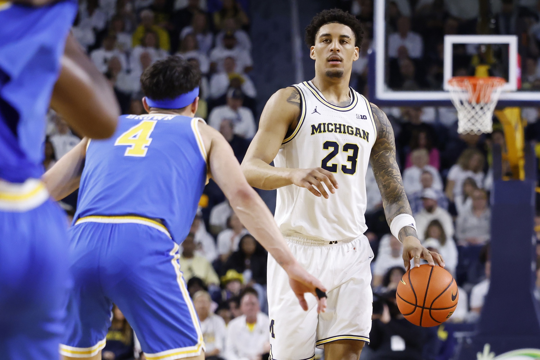 Michigan Wolverines forward Yaxel Lendeborg (23) is defended by UCLA Bruins guard Jamar Brown (4) in the first half at Crisler Center.