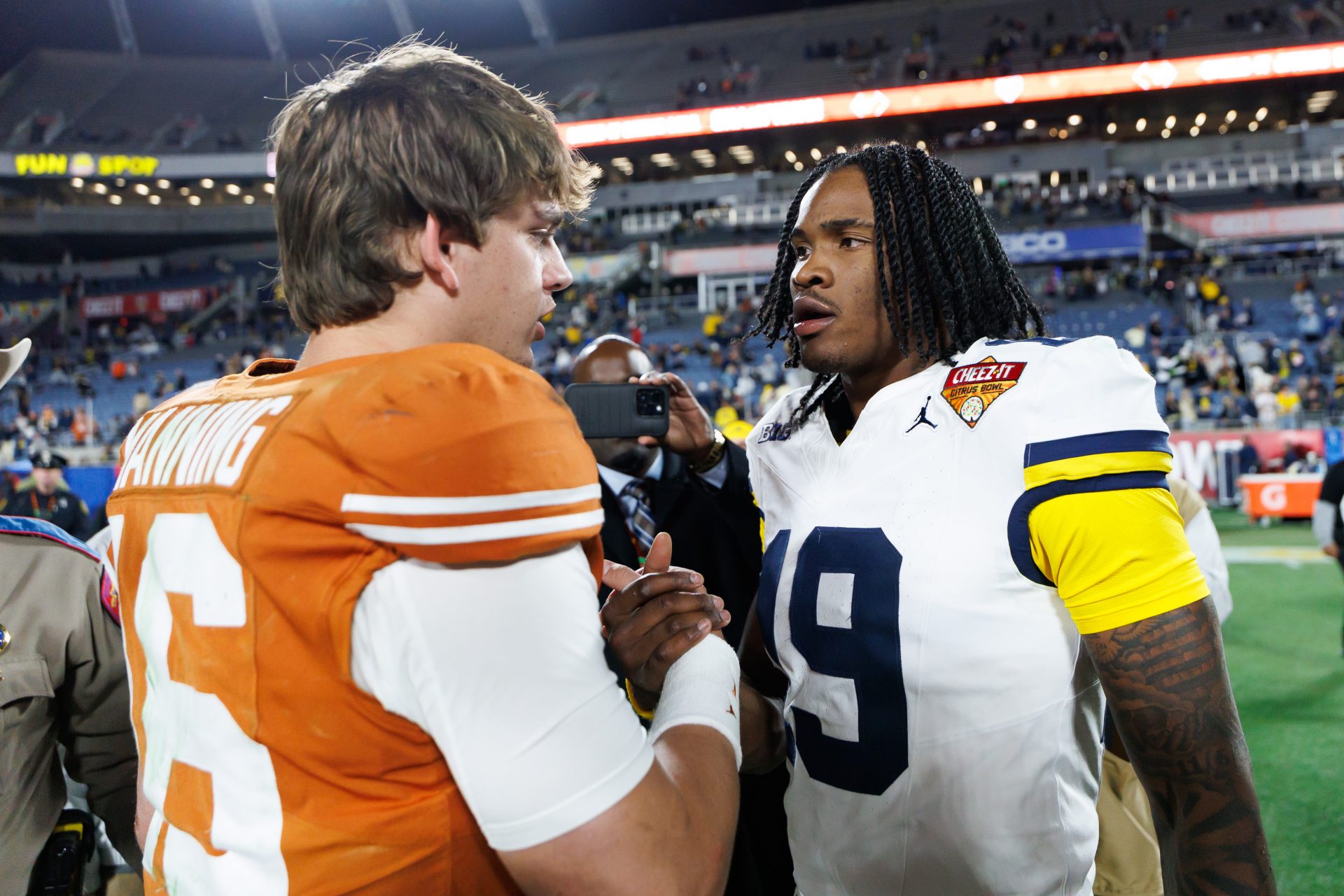Texas Longhorns quarterback Arch Manning (16) and Michigan Wolverines quarterback Bryce Underwood (19) shake hands after a game at Camping World Stadium.