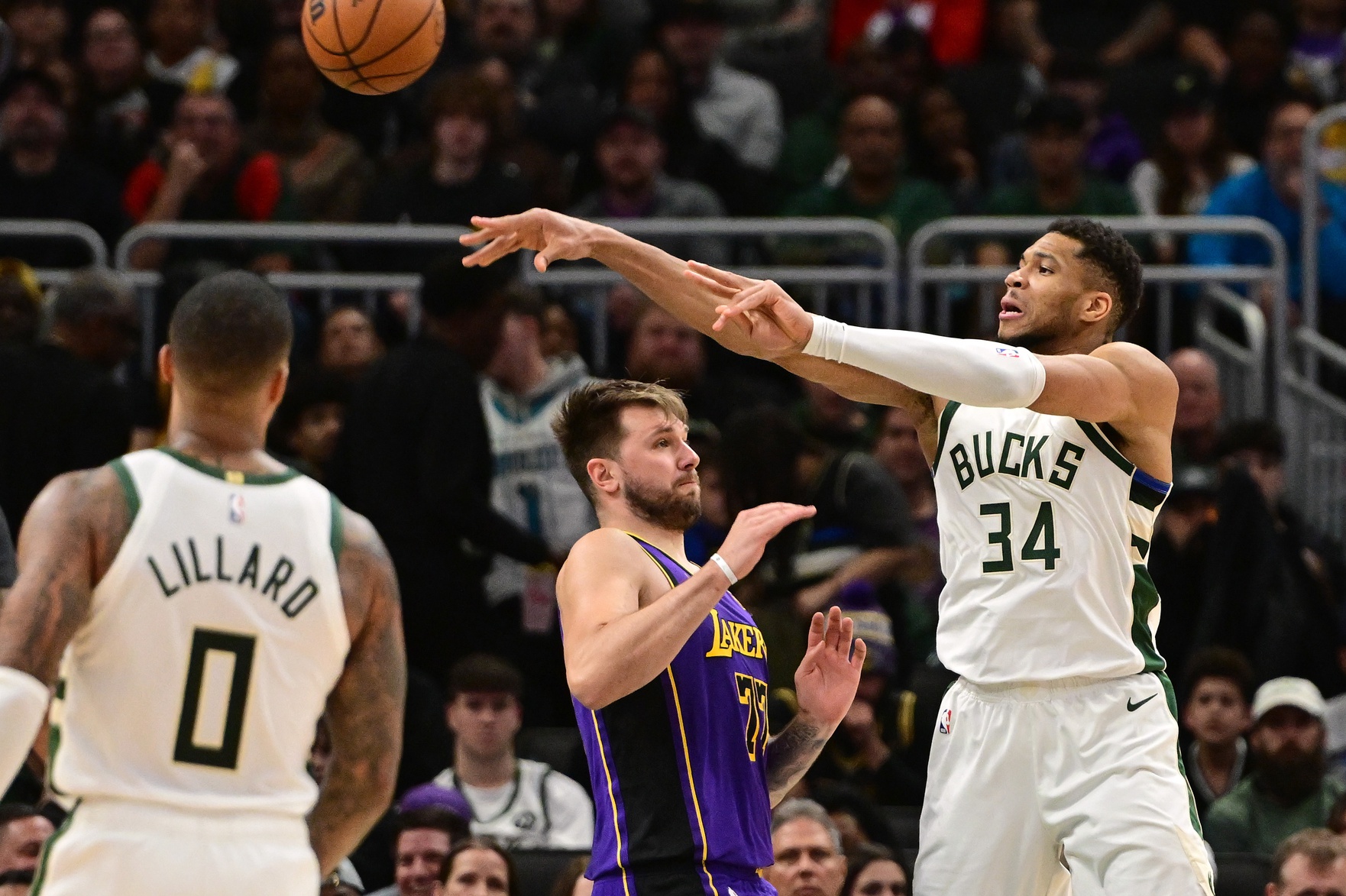 Milwaukee Bucks forward Giannis Antetokounmpo (34) passes the ball over Los Angeles Lakers guard Luka Doncic (77) in the fourth quarter at Fiserv Forum.