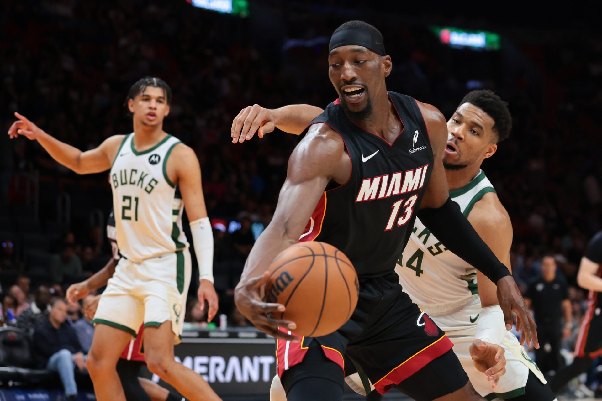 Miami Heat center Bam Adebayo (13) protects the basketball against Milwaukee Bucks forward Giannis Antetokounmpo (34) during the third quarter at Kaseya Center - Source: Imagn Images