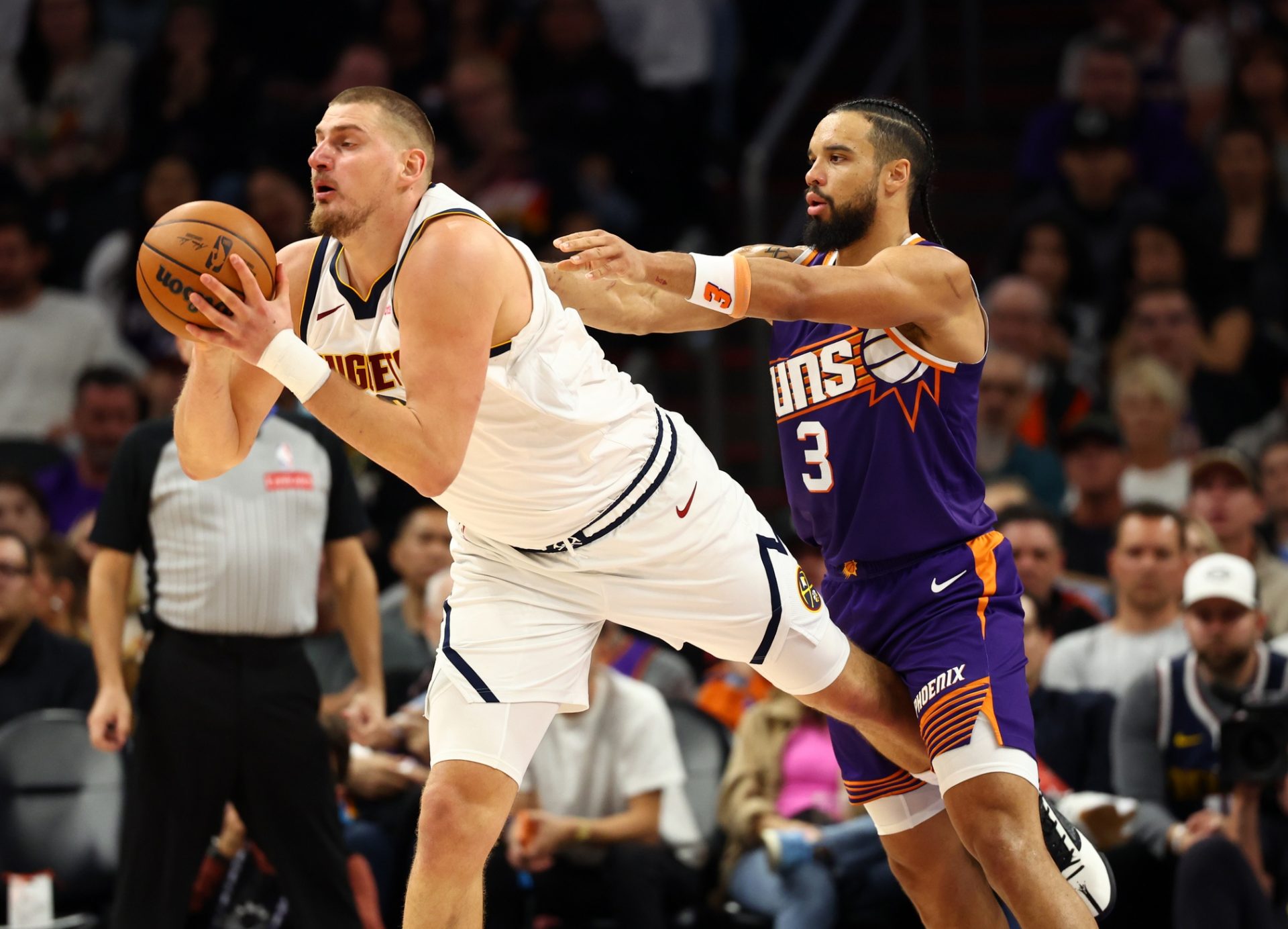Denver Nuggets center Nikola Jokic (15) is fouled by Phoenix Suns forward Dillon Brooks (3) in the first half at the Mortgage Matchup Center.