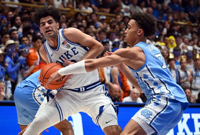 Duke Blue Devils guard Cayden Boozer (2) drives to the basket as North Carolina Tar Heels guard Seth Trimble (7) defends during the second half at Cameron Indoor Stadium - Source: Imagn