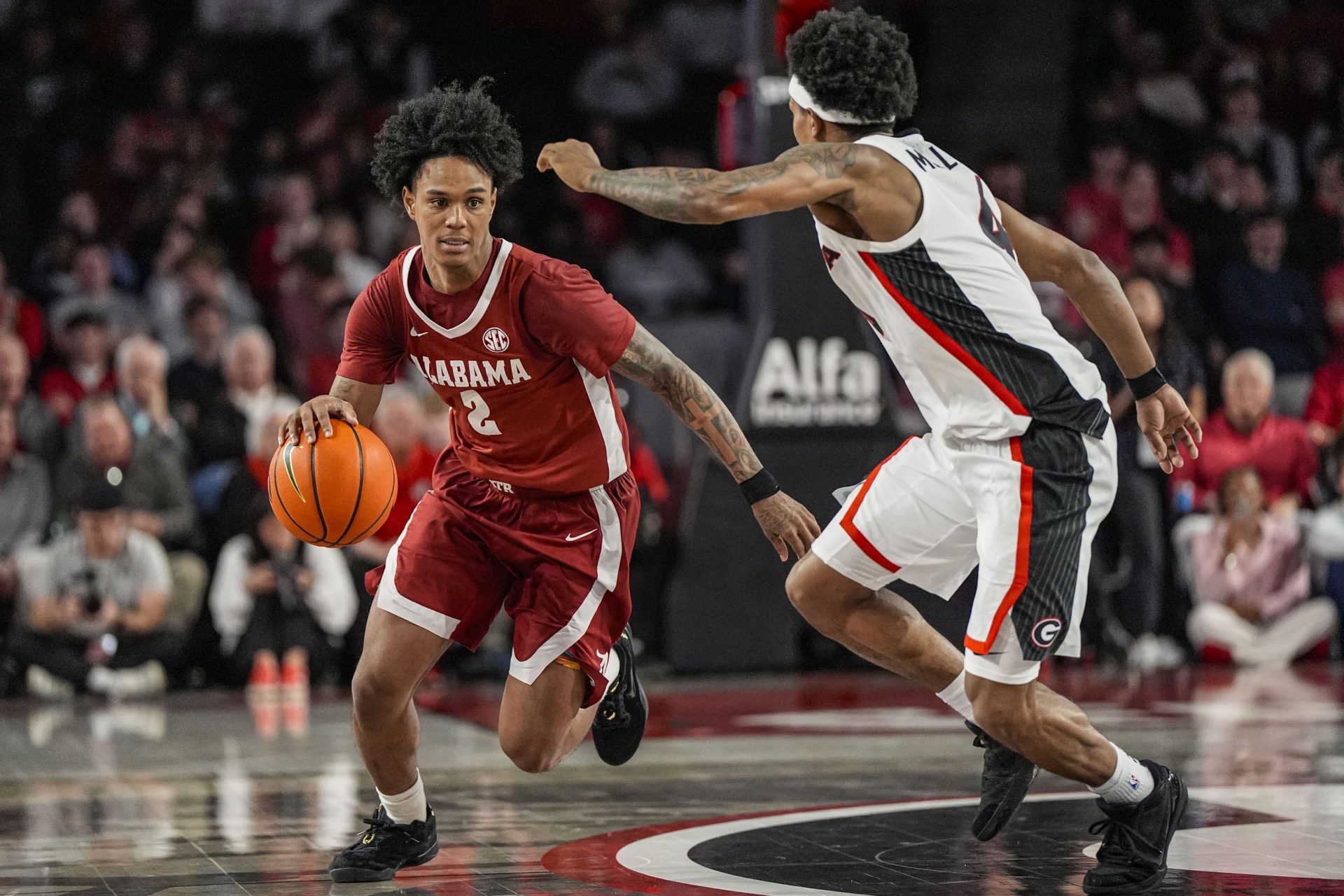 Alabama Crimson Tide guard Aden Holloway (2) dribbles against Georgia Bulldogs guard Marcus Millender (4) at Stegeman Coliseum.