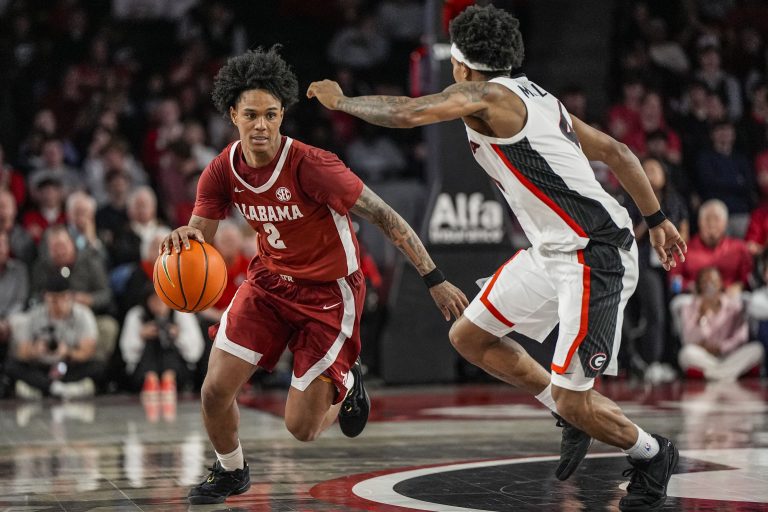 Alabama Crimson Tide guard Aden Holloway (2) dribbles against Georgia Bulldogs guard Marcus Millender (4) at Stegeman Coliseum.