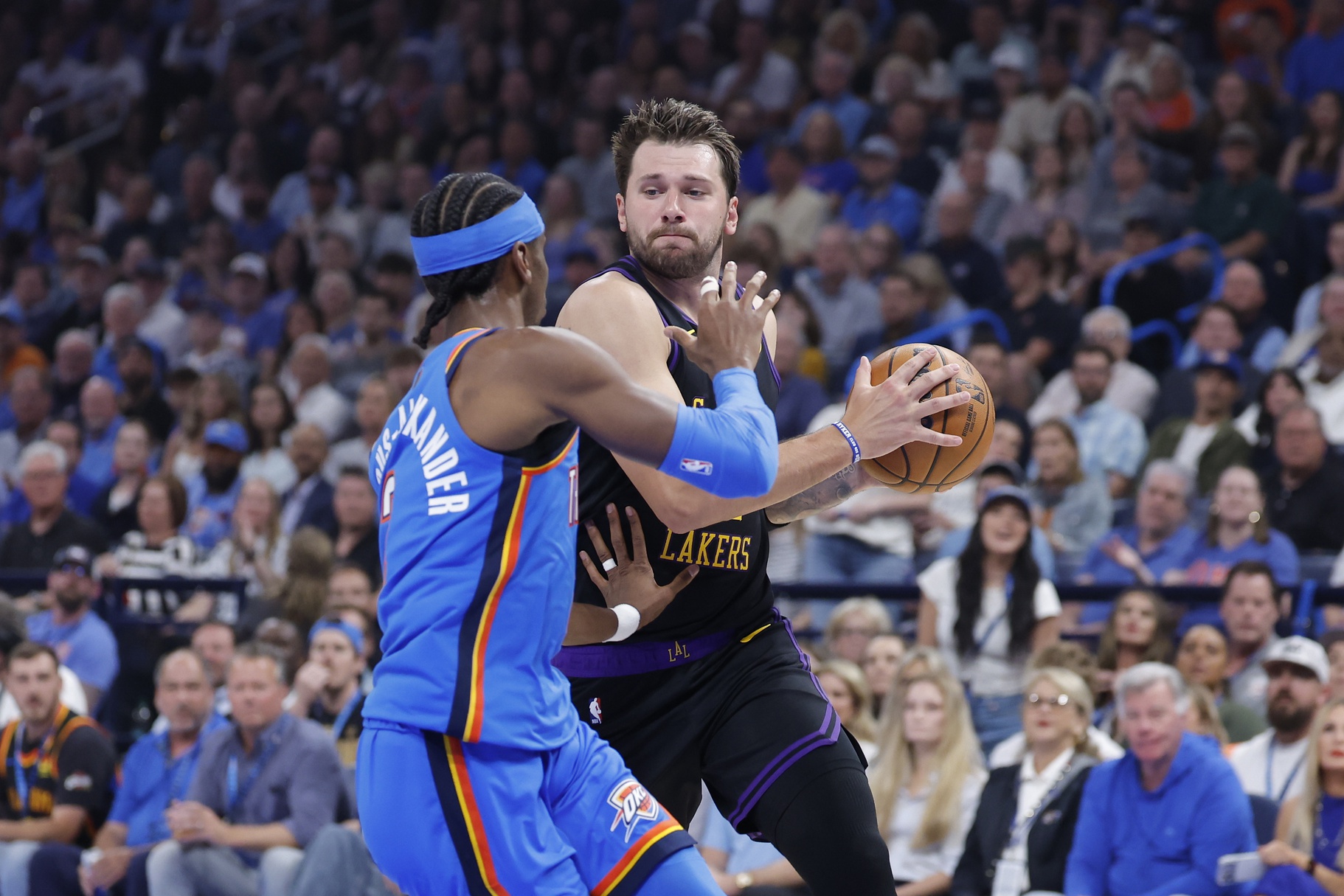 Los Angeles Lakers guard Luka Doncic (77) drives to the basket against Oklahoma City Thunder guard Shai Gilgeous-Alexander (2) during the first quarter at Paycom Center.