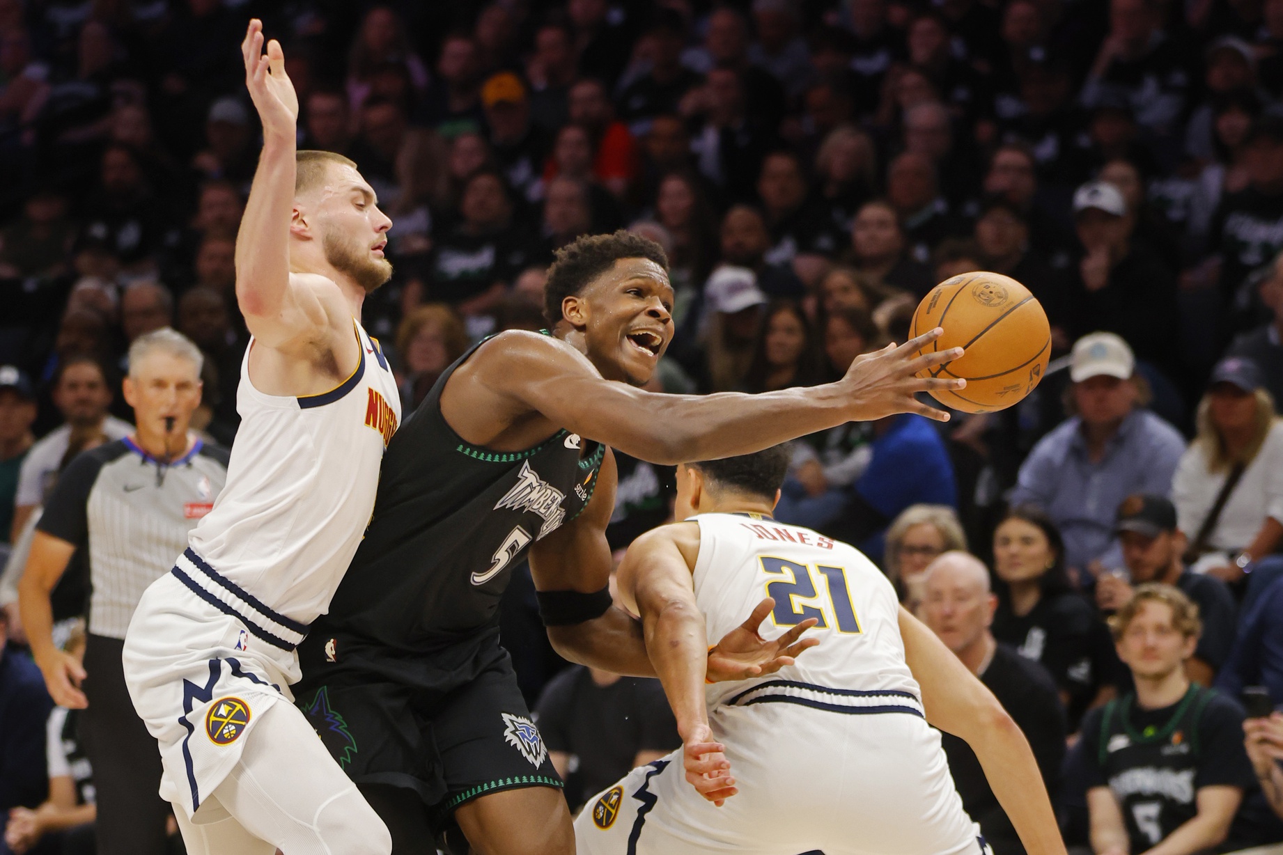 Denver Nuggets forward Spencer Jones (21) fouls Minnesota Timberwolves guard Anthony Edwards (5) as forward Christian Braun (0) defends in the first quarter at Target Center.