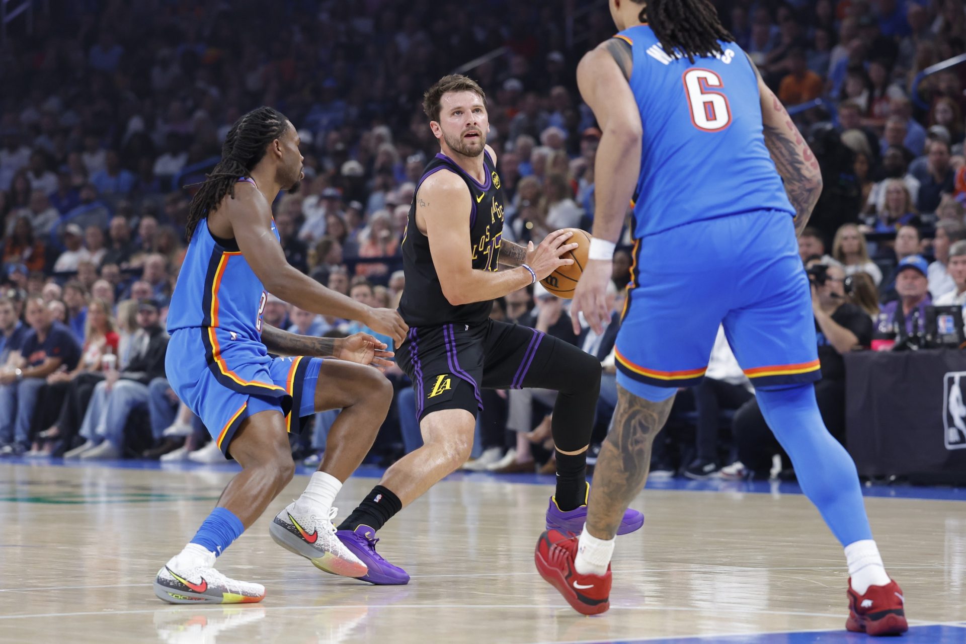 Los Angeles Lakers guard Luka Doncic (77) moves the ball down the court beside Oklahoma City Thunder guard Cason Wallace (22) during the first quarter at Paycom Center.