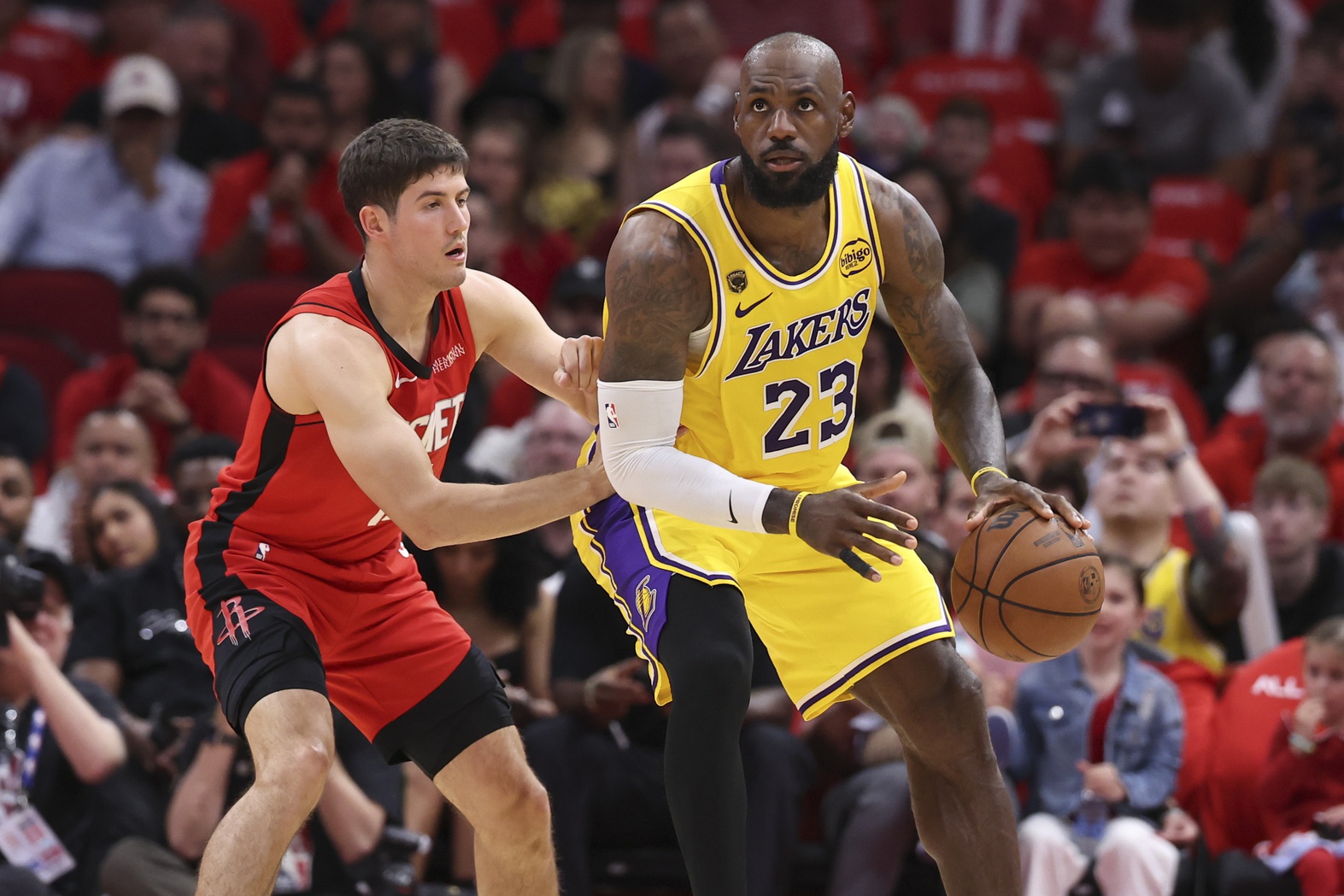 Los Angeles Lakers forward LeBron James (23) controls the ball as Los Angeles Lakers guard Austin Reaves (15) defends during the first quarter during game three of the first round of the 2026 NBA Playoffs at Toyota Center.