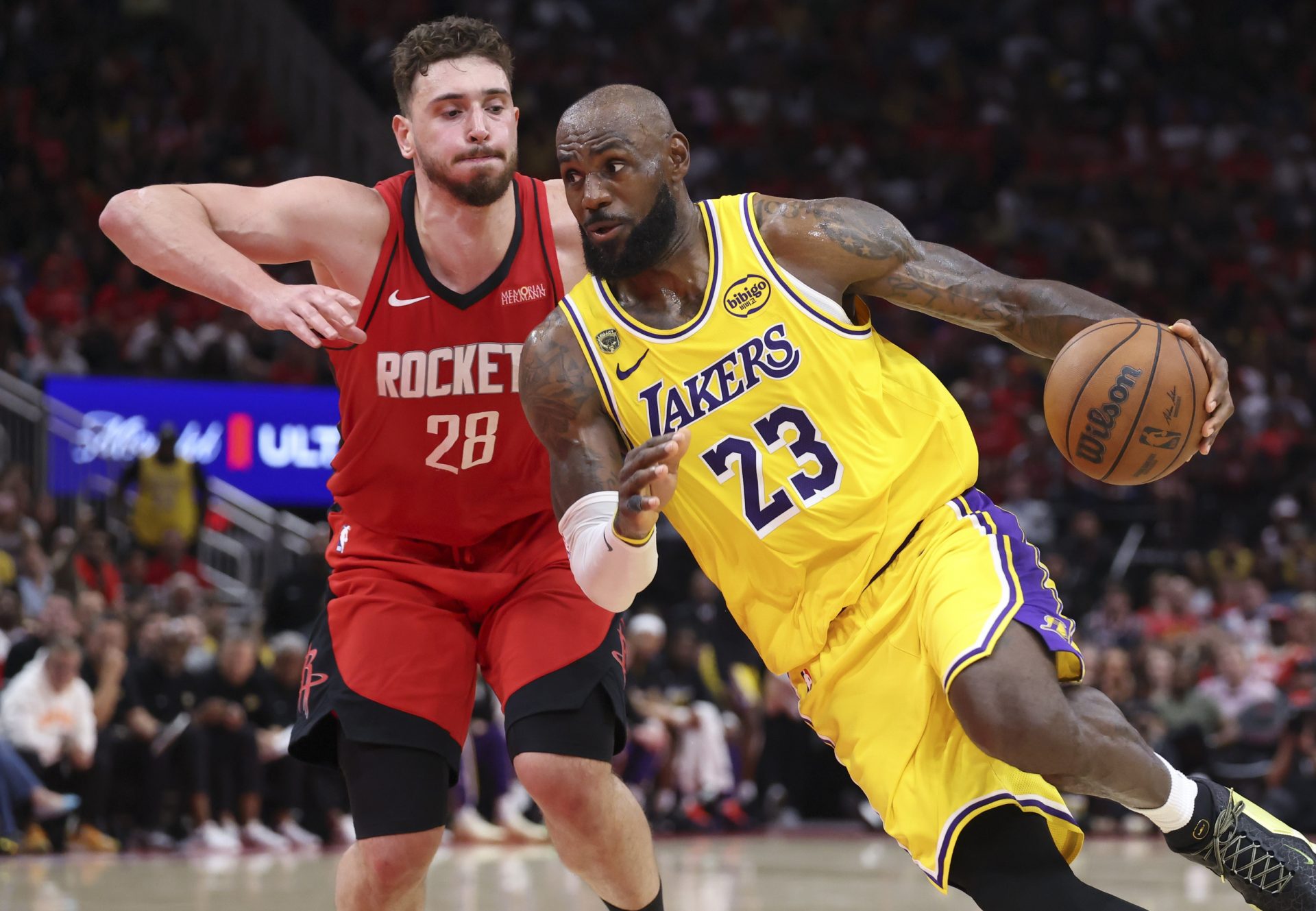 Los Angeles Lakers forward LeBron James (23) drives with the ball as Houston Rockets center Alperen Sengun (28) defends during the fourth quarter during game three of the first round of the 2026 NBA Playoffs at Toyota Center.