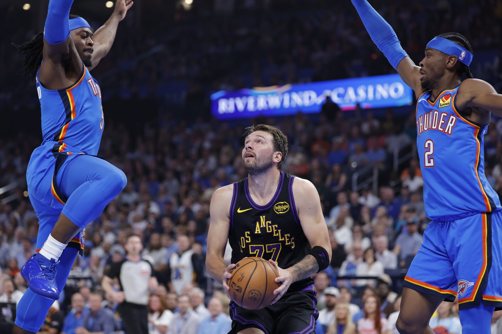 Los Angeles Lakers guard Luka Doncic (77) drives between Oklahoma City Thunder guard Luguentz Dort (5) and guard Shai Gilgeous-Alexander (2) during the first quarter at Paycom Center. - Source: Imagn