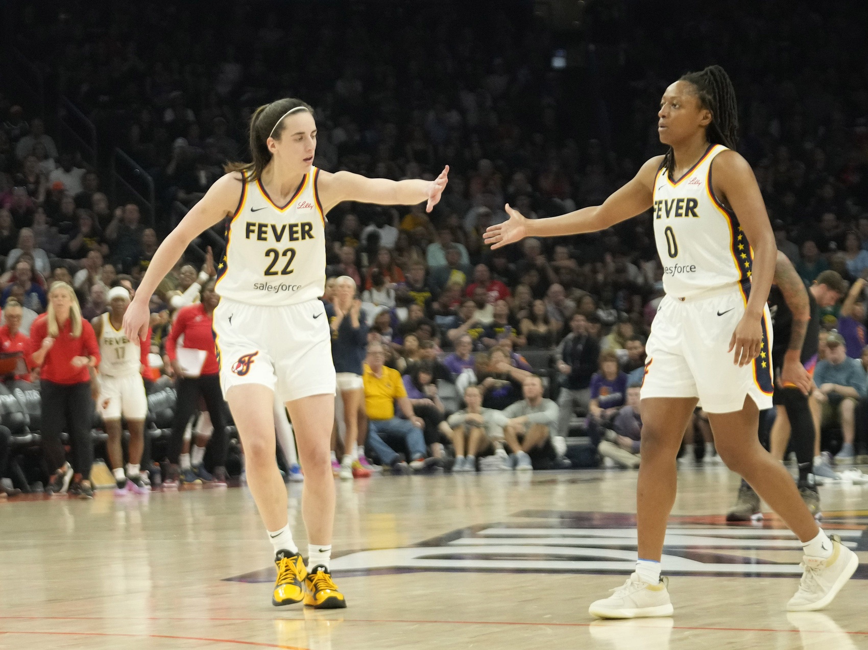 Indiana Fever guard Caitlin Clark (22) slaps hands with guard Kelsey Mitchell (0) during the third quarter against the Phoenix Mercury at Footprint Center. - Source: USA Today Network