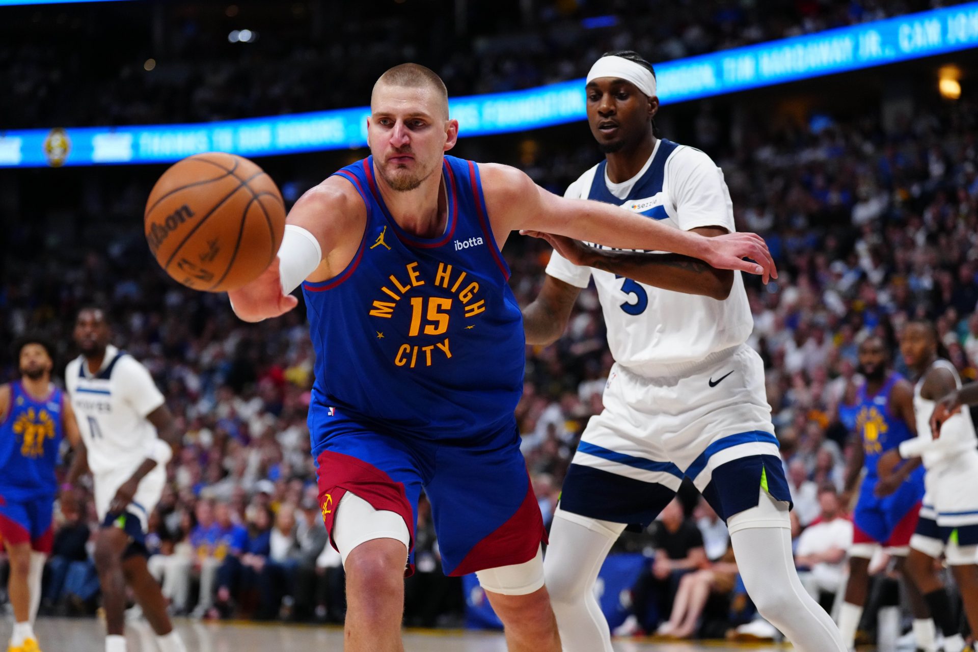 Minnesota Timberwolves forward Jaden McDaniels (3) defends on Denver Nuggets center Nikola Jokic (15) in the second half during game two of the first round of the 2026 NBA Playoffs at Ball Arena.