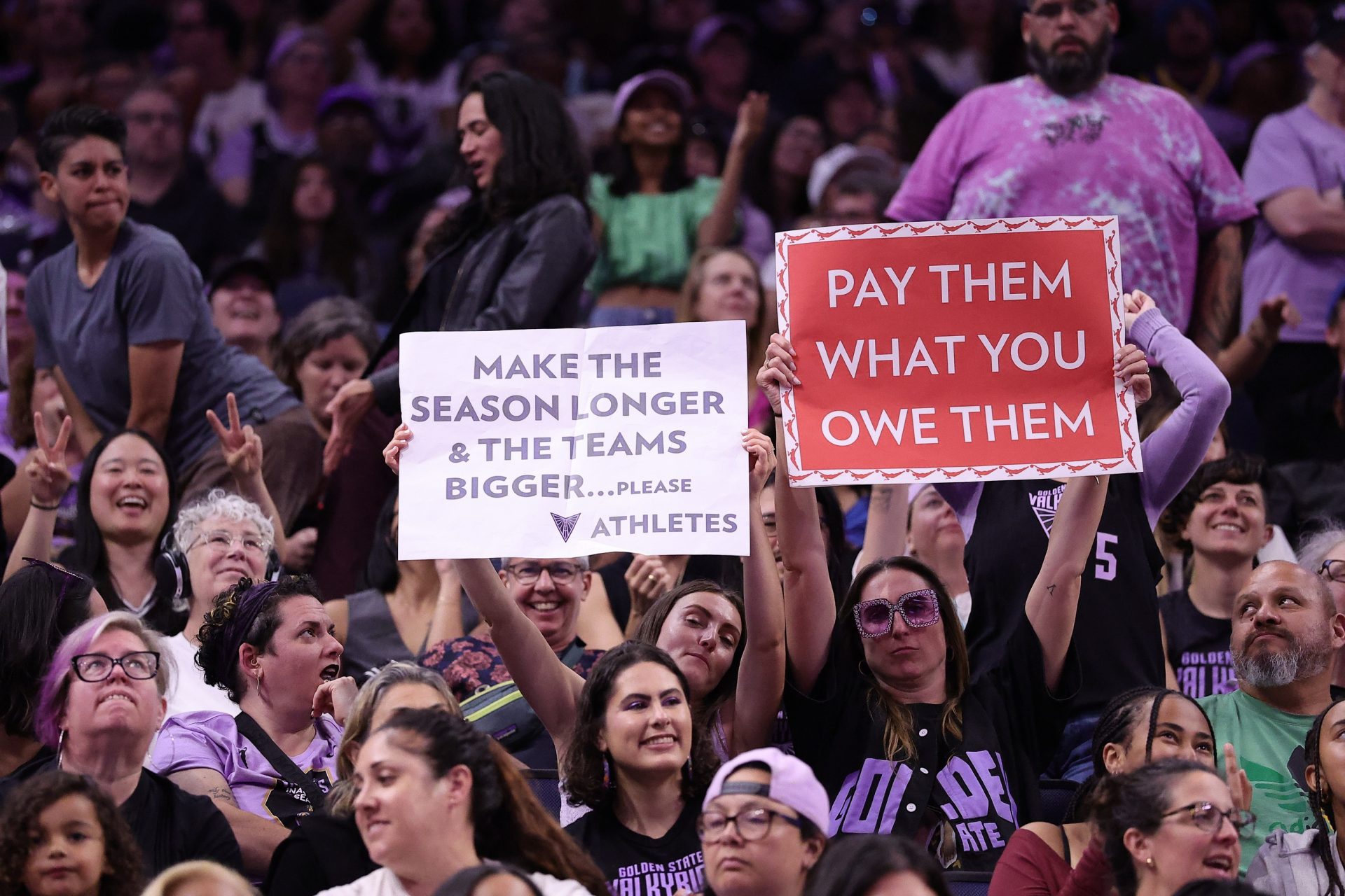 Golden State Valkyries fans hold signs to “make the season long and the teams bigger” and “pay them what you owe them” during the fourth quarter against the Washington Mystics at Chase Center - Source: Imagn Images