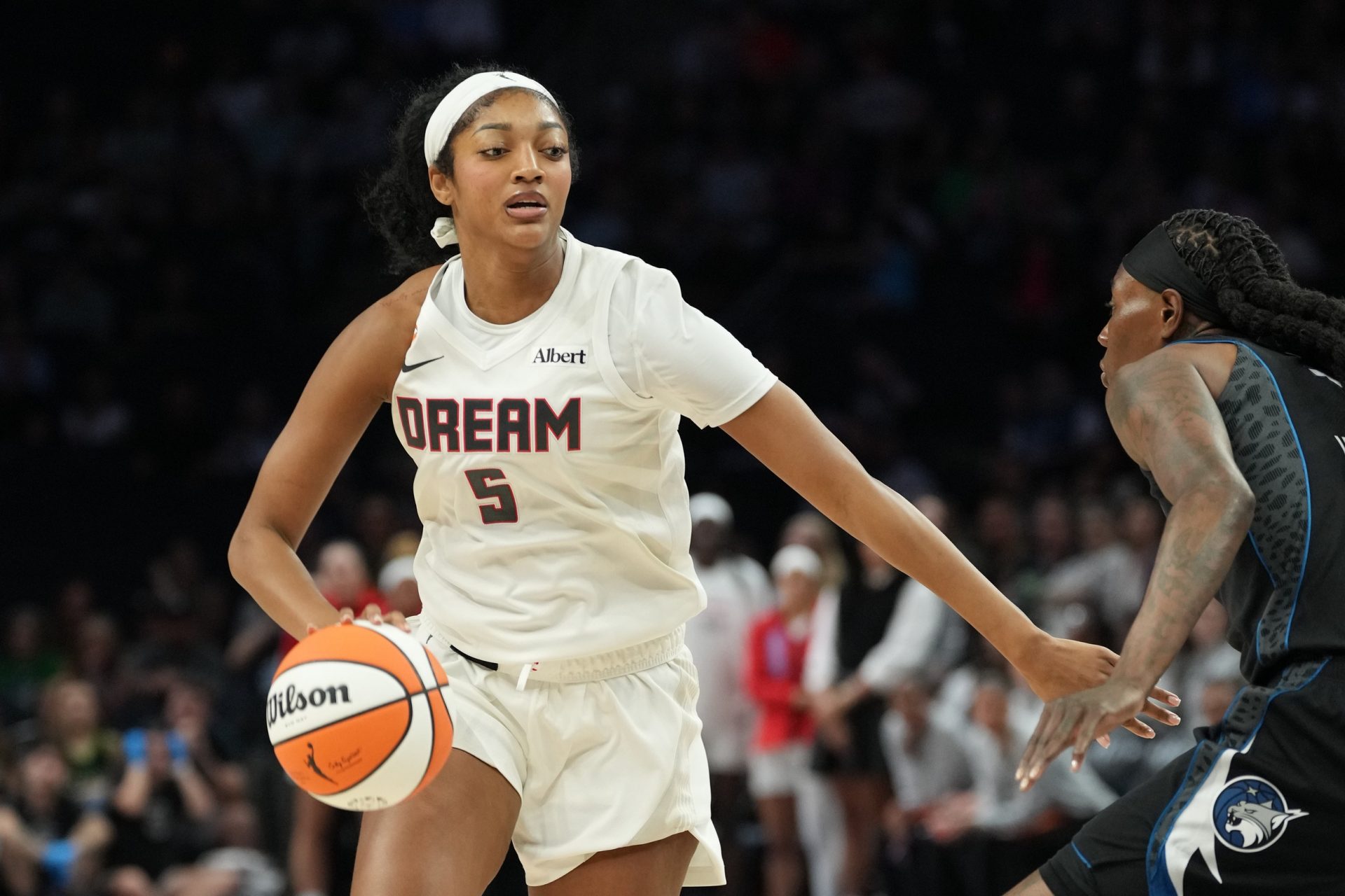 Atlanta Dream forward Angel Reese (5) dribbles the ball as Minnesota Lynx forward Natasha Howard (1) plays defense in the first half at Target Center - Source: Imagn Images