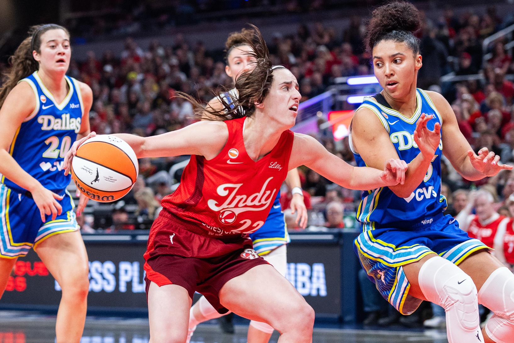 Indiana Fever guard Caitlin Clark (22) dribbles the ball while Dallas Wings guard Azzi Fudd (35) defends in the first half at Gainbridge Fieldhouse.