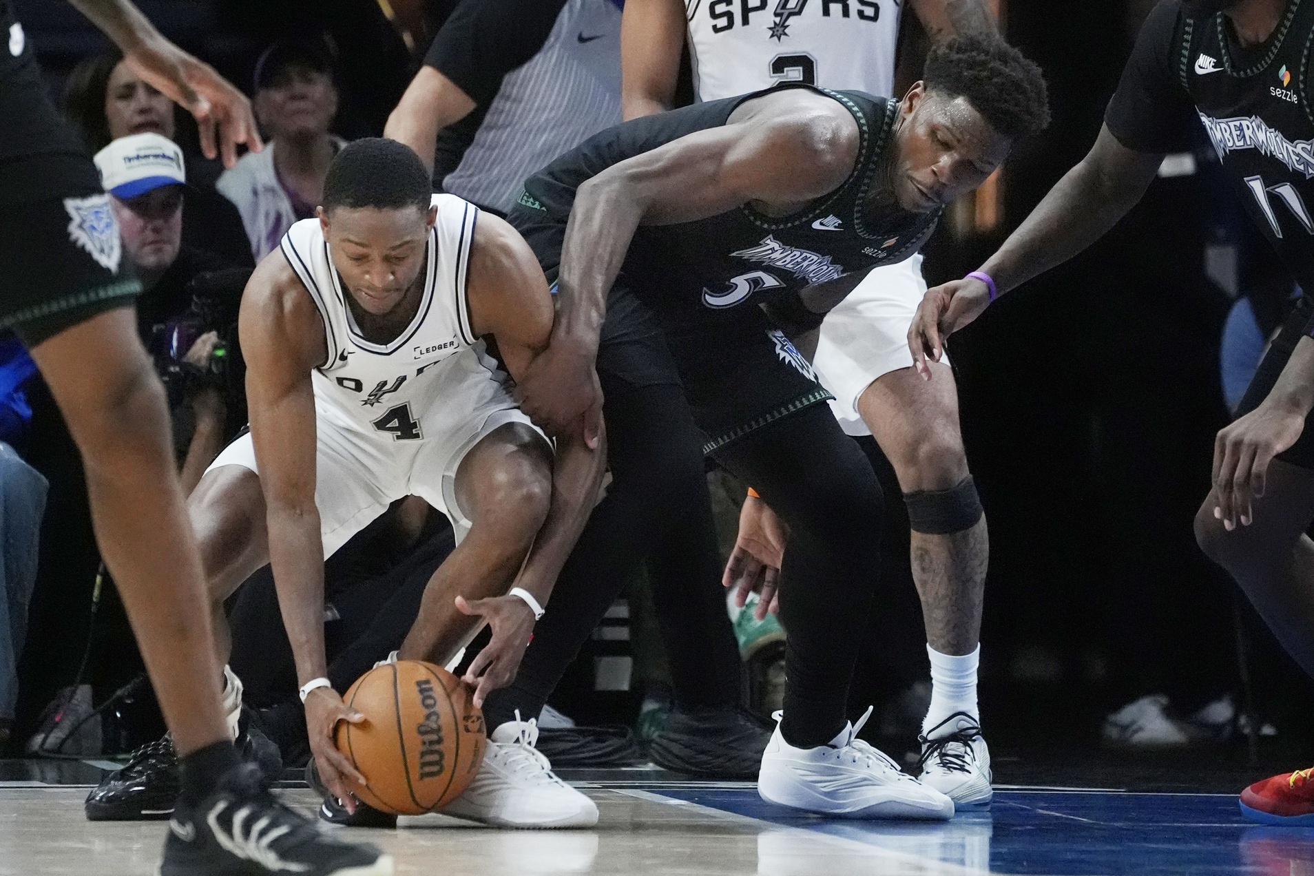 San Antonio Spurs guard De'Aaron Fox (4) challenges Minnesota Timberwolves guard Anthony Edwards (5) for the ball in the fourth quarter of game four of the second round of the 2026 NBA Playoffs at Target Center.