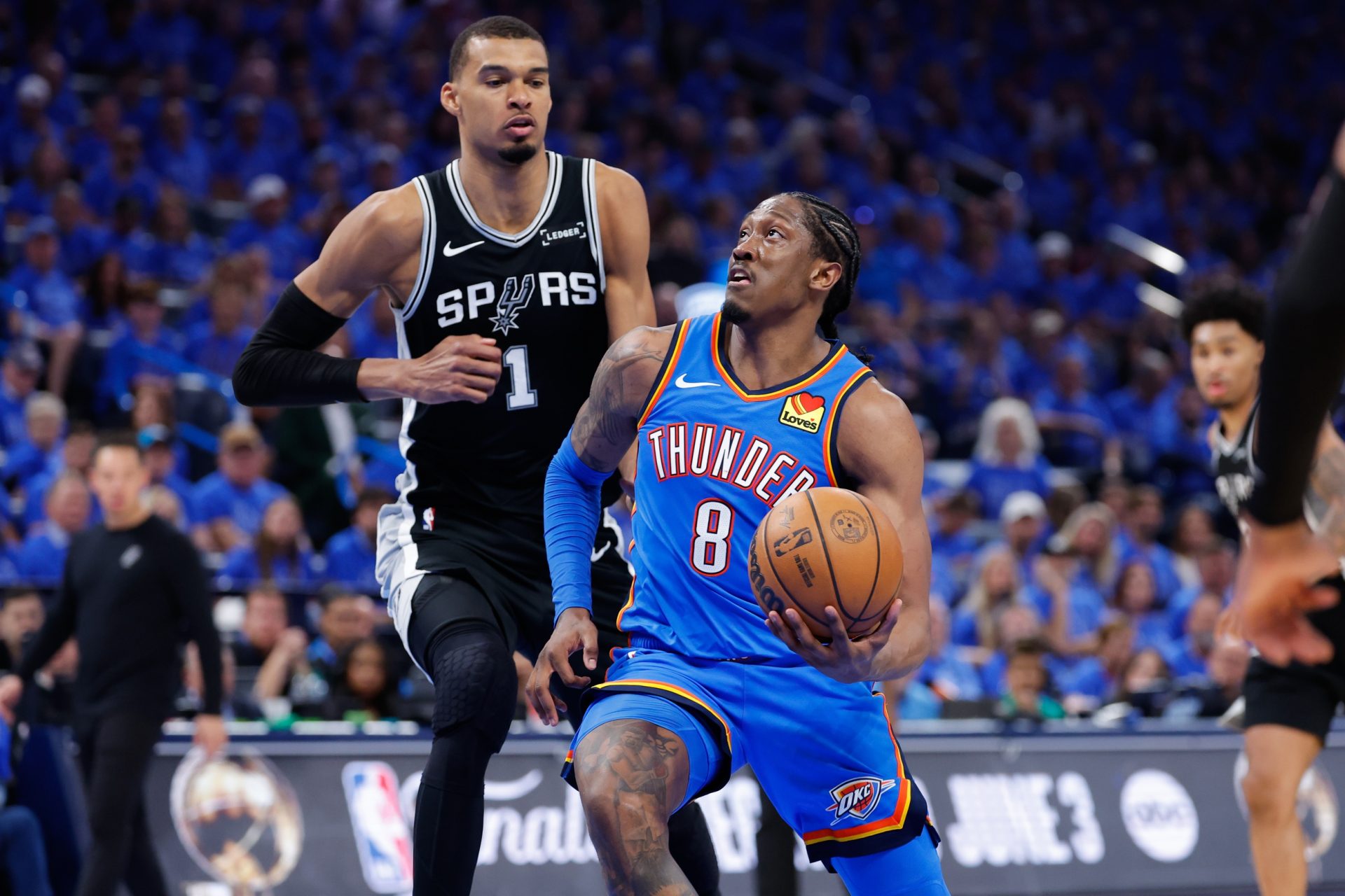 Oklahoma City Thunder forward Jalen Williams (8) drives the ball past San Antonio Spurs center Victor Wembanyama (1) in the third quarter during game one of the western conference finals for the 2026 NBA playoffs at Paycom Center.