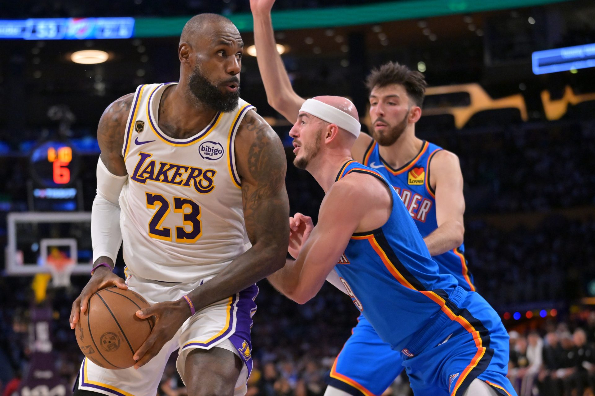 Los Angeles Lakers forward LeBron James (23) is defended by Oklahoma City Thunder guard Alex Caruso (9) and center Chet Holmgren (7) in the first half of game three of the second round of the 2026 NBA Playoffs at Crypto.com Arena - Source: Imagn Images