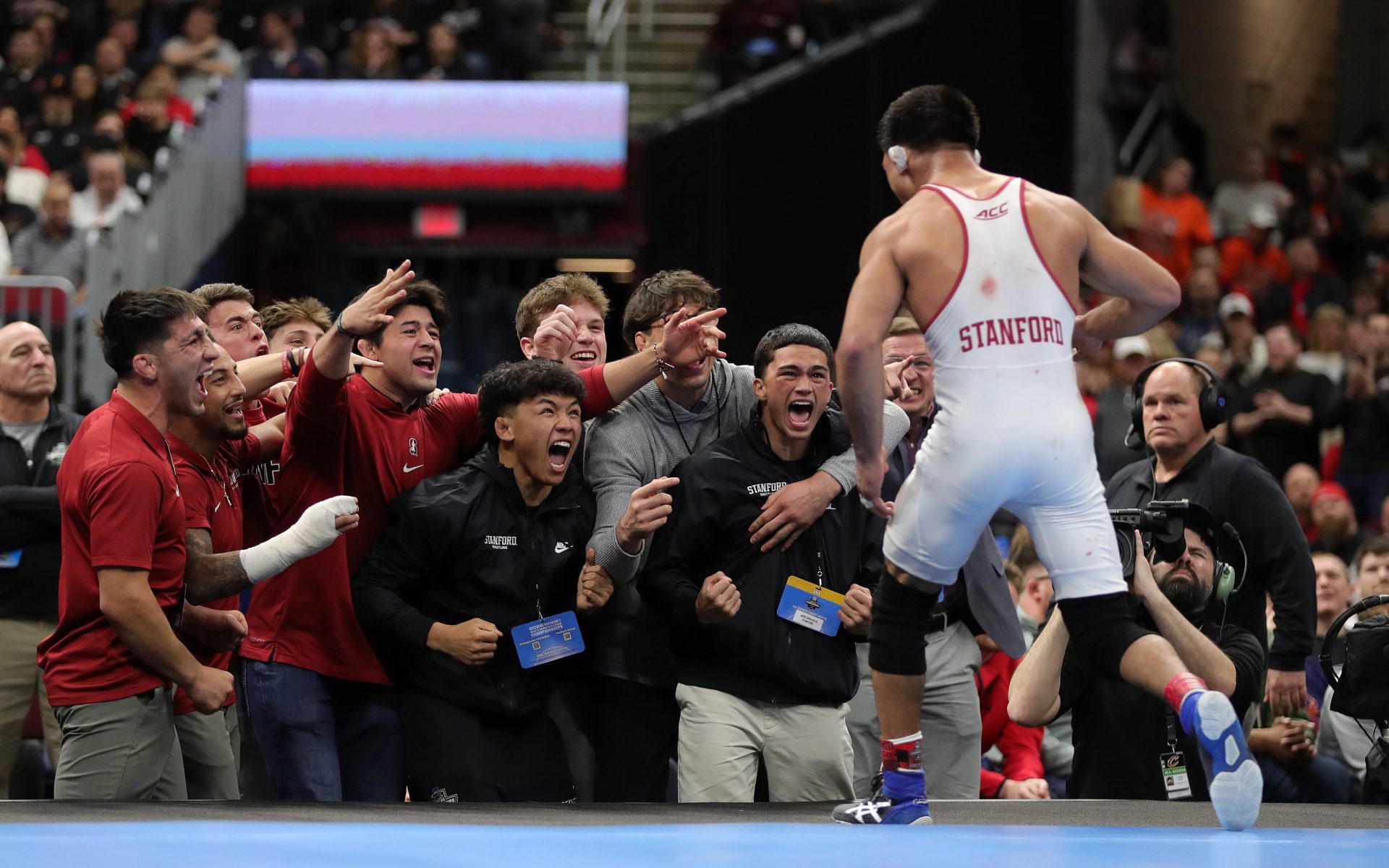 Stanford’s Aden Valencia runs back to his team after beating Penn State’s Shayne Van Ness in the 149 pound finals match in the NCAA Division I wrestling championships at Rocket Arena, March 21, 2026, in Cleveland, Ohio.