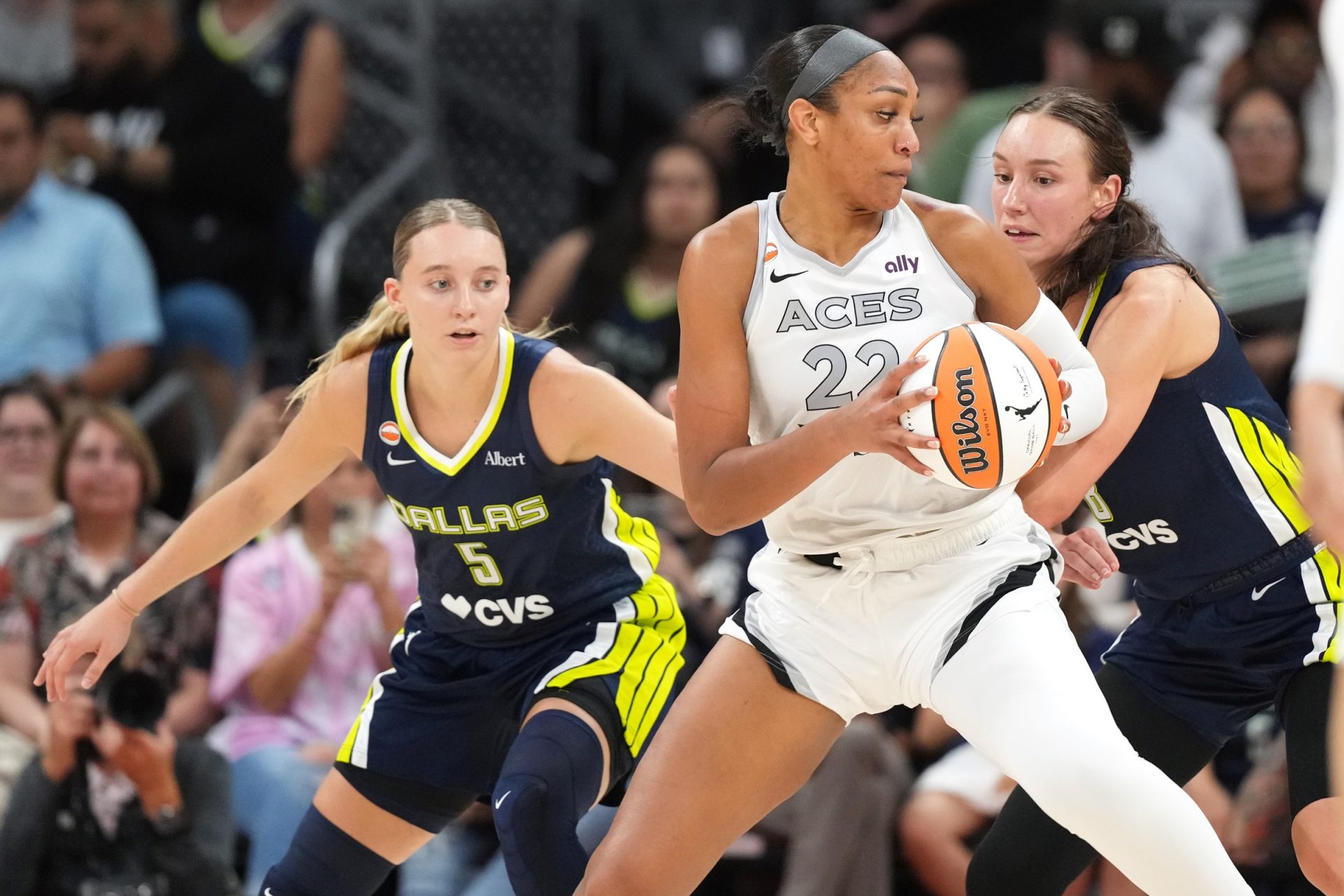 Las Vegas Aces center A’ja Wilson (22) drives to the basket against Dallas Wings guard Paige Bueckers (5) and forward Alanna Smith (8) during the first half at Moody Center - Source: Imagn Images
