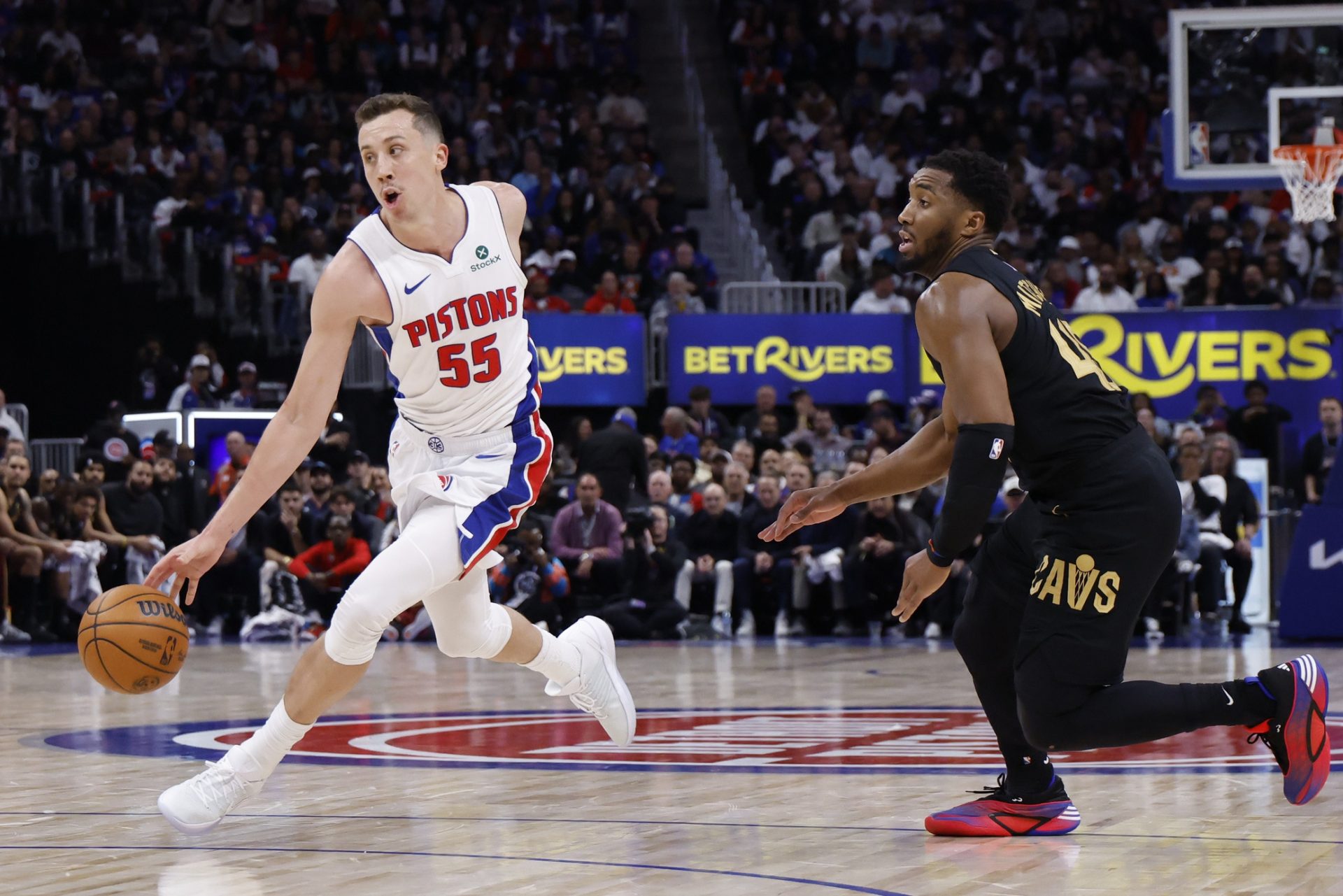 Detroit Pistons forward Duncan Robinson (55) dribbles defended by Cleveland Cavaliers guard Donovan Mitchell (45) in the second half during game one of the second round of the 2026 NBA Playoffs at Little Caesars Arena.
