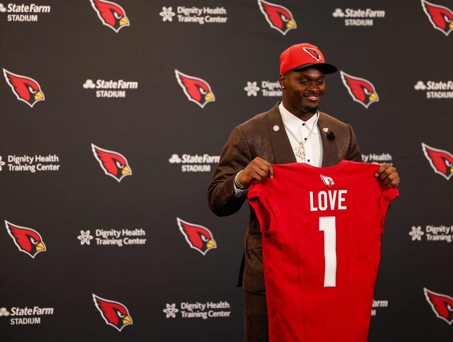 Arizona Cardinals first-round draft pick Jeremiyah Love poses with his jersey during a press conference at Dignity Health Arizona Cardinals Training Center.