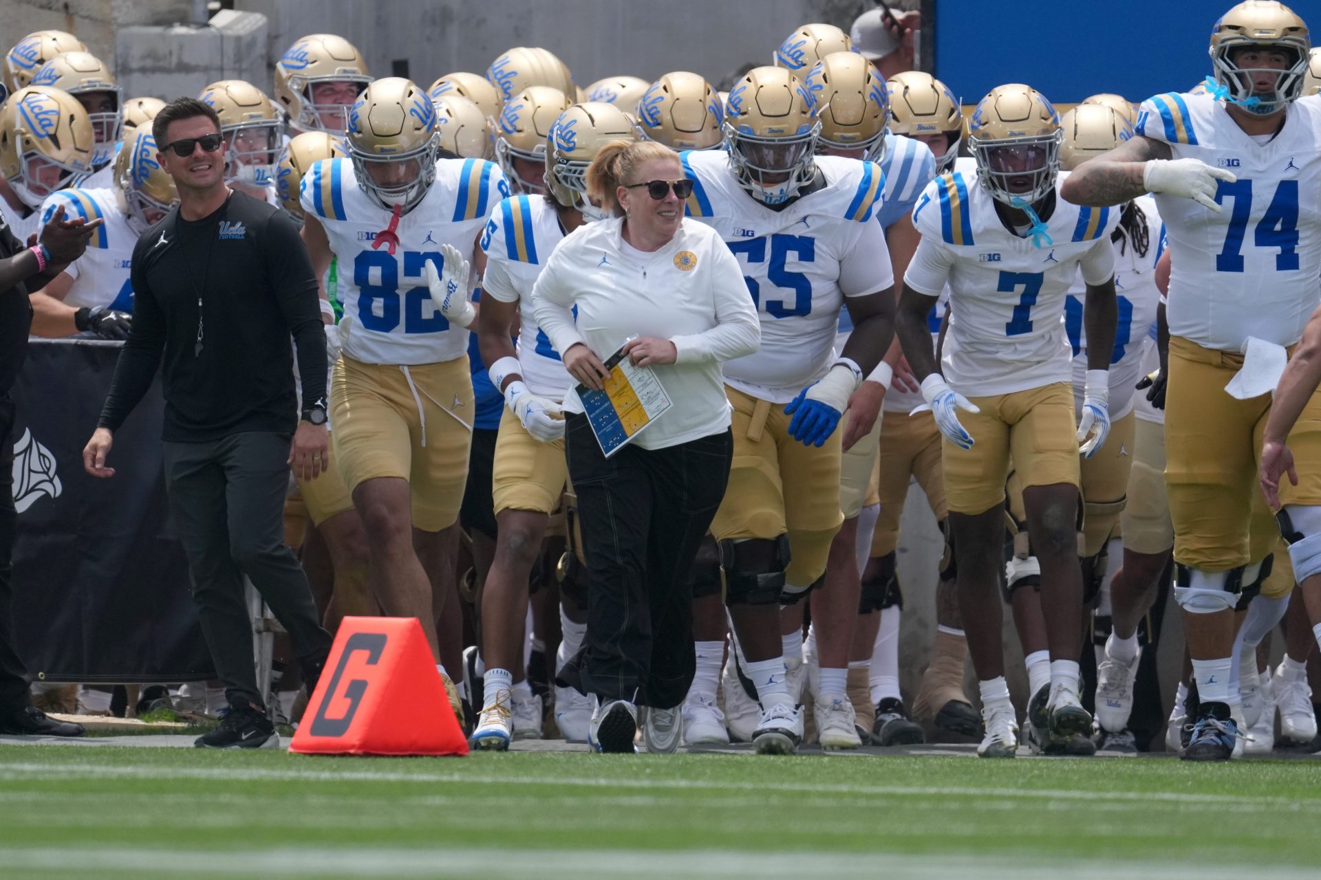 UCLA Bruins coach Bob Chesney and women's basketball coach Cori Close lead players onto the field during the spring game at Rose Bowl. Source: Kirby Lee-Imagn Images