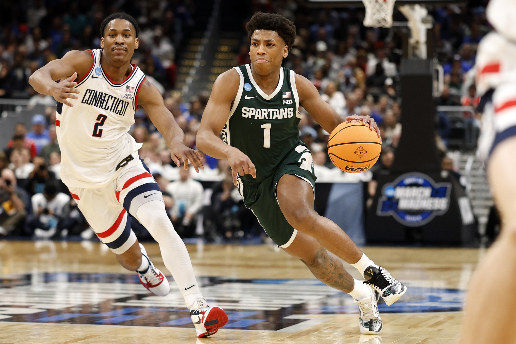 Michigan State Spartans guard Jeremy Fears Jr. (1) dribbles the ball past UConn Huskies guard Silas Demary Jr. (2) in the first half during a Sweet Sixteen game of the East Regional of the men's 2026 NCAA Tournament at Capital One Arena.