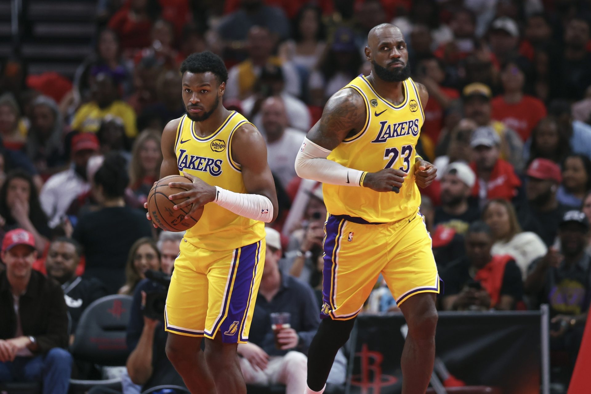 Los Angeles Lakers forward LeBron James (23) gives the ball to guard Bronny James (9) during the fourth quarter against the Houston Rockets during game three of the first round of the 2026 NBA Playoffs at Toyota Center. Source: Imagn