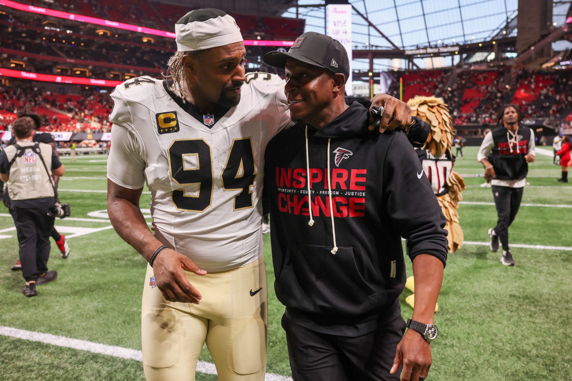 New Orleans Saints defensive end Cameron Jordan (94) walks with Atlanta Falcons head coach Raheem Morris after a game at Mercedes-Benz Stadium.