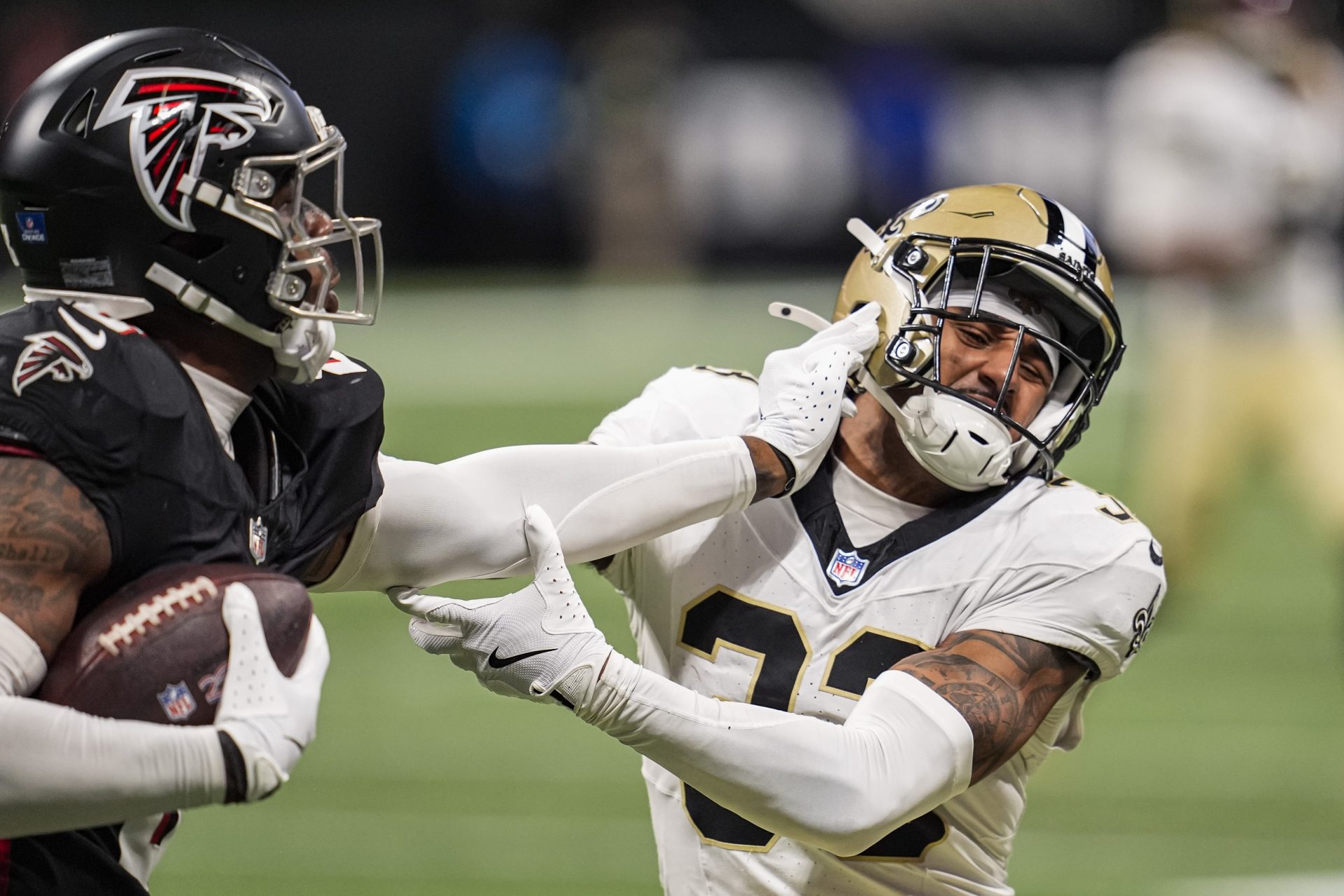 New Orleans Saints safety Jonas Sanker (33) takes a straight arm from Atlanta Falcons tight end Kyle Pitts Sr. (8) during the second half at Mercedes-Benz Stadium.
