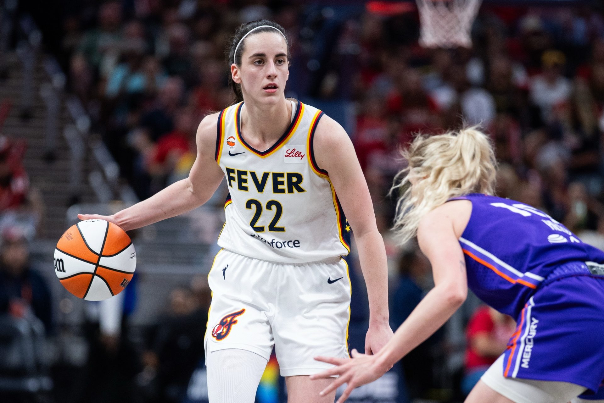 Indiana Fever guard Caitlin Clark (22) dribbles the ball while Phoenix Mercury guard Lexi Held (10) defends in the second half at Gainbridge Fieldhouse.