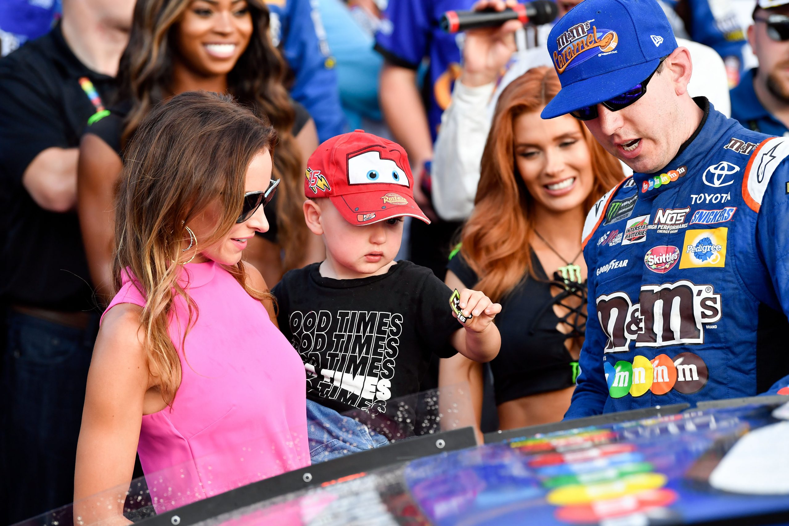 Sep 24, 2017; Loudon, NH, USA; Monster Energy NASCAR Cup Series driver Kyle Busch (right) watches as his son Brexton and wife Samantha place a winner sticker on his car after finishing first in the ISM Connect 300 at the New Hampshire Motor Speedway. Mandatory Credit: Brian Fluharty-Imagn Images